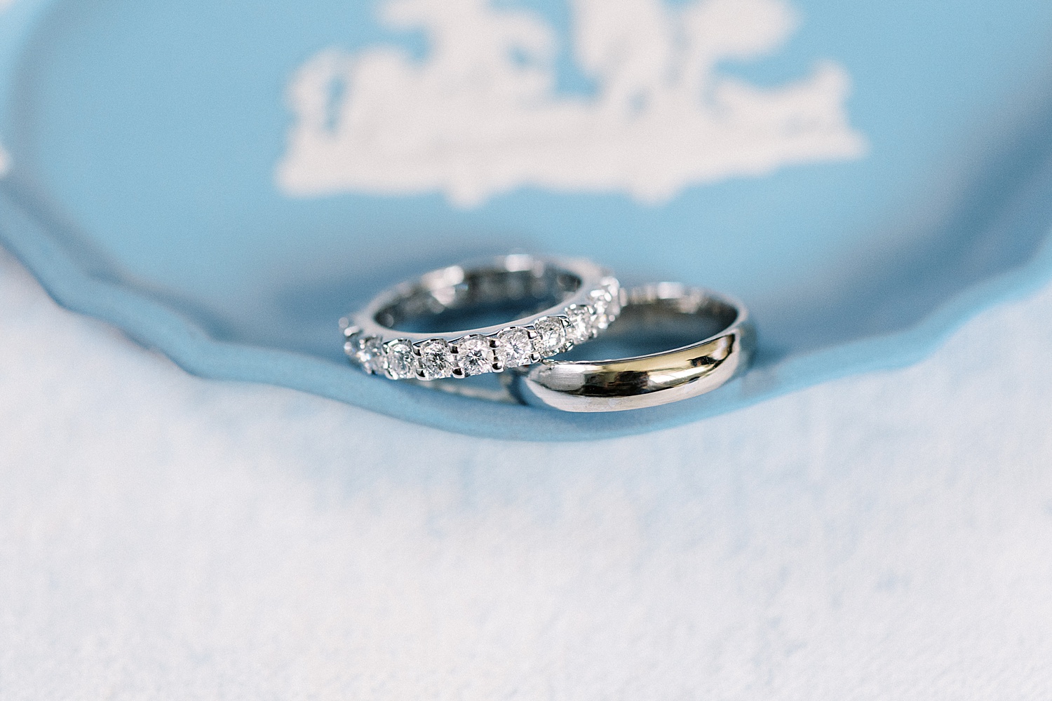 Diamond rings on blue dish by Massachusetts wedding photographer