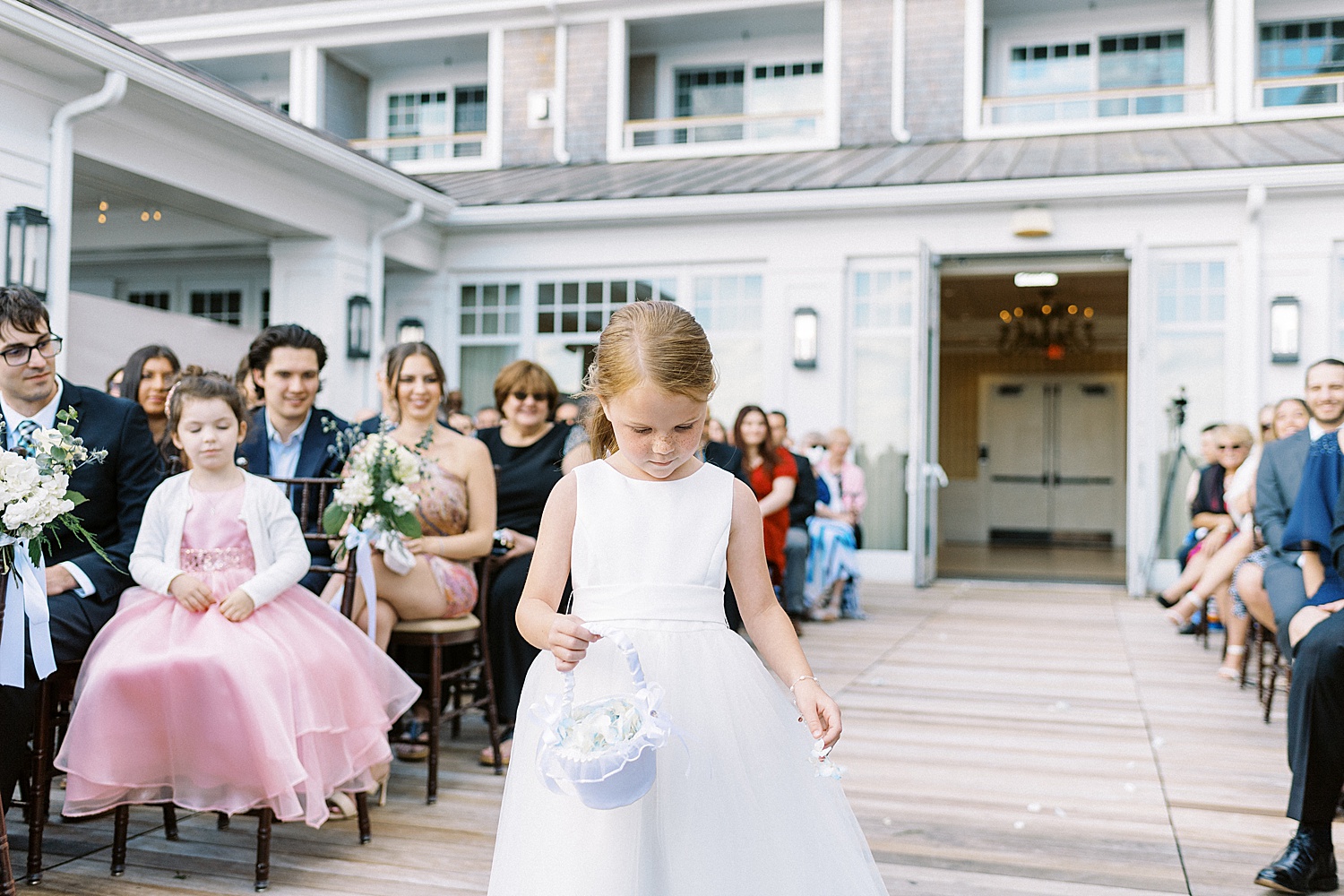 Flowergirl walking down the aisle on outside deck at Beauport Hotel