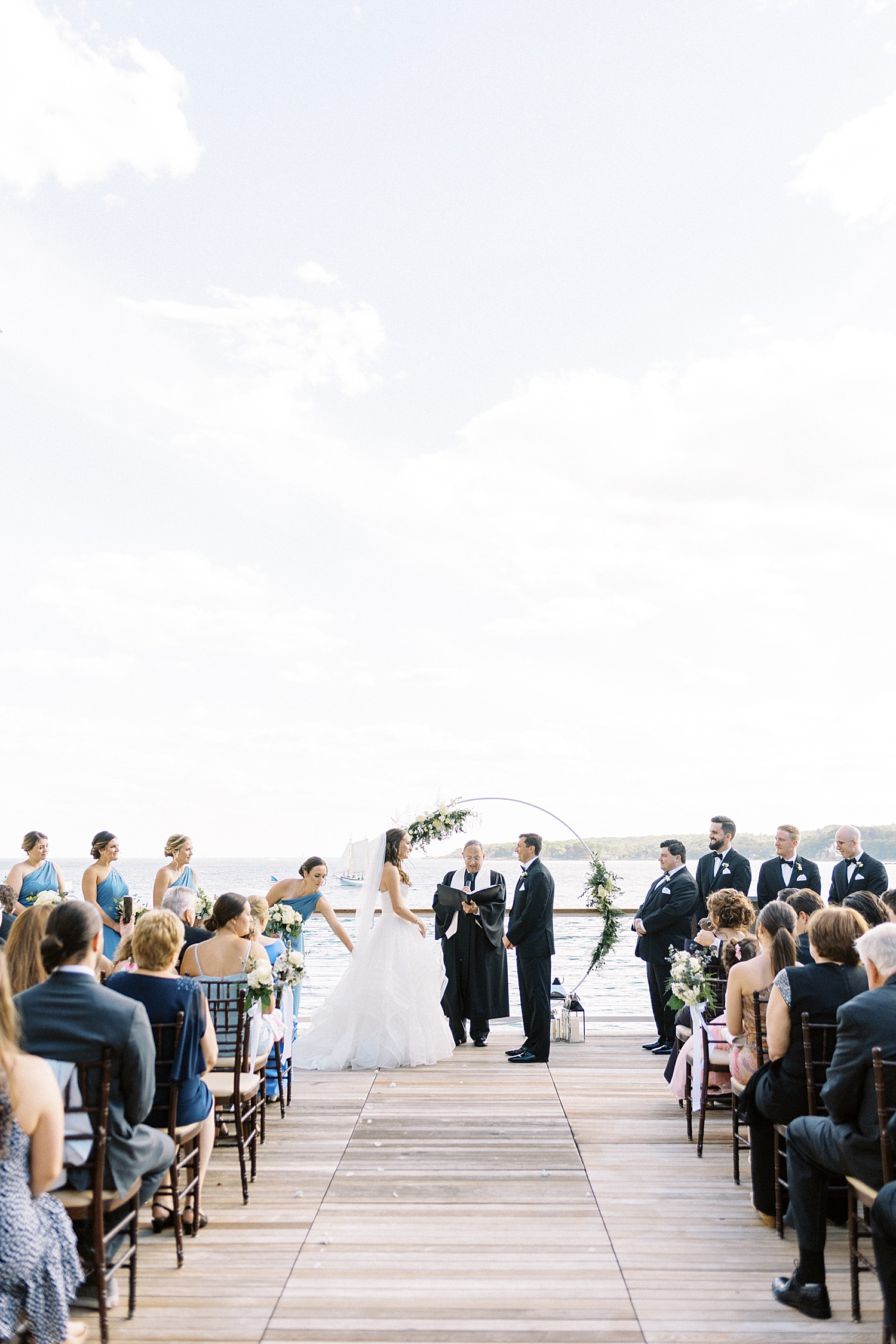 Bride and groom at the alter in front of water by Lynne Reznick photography