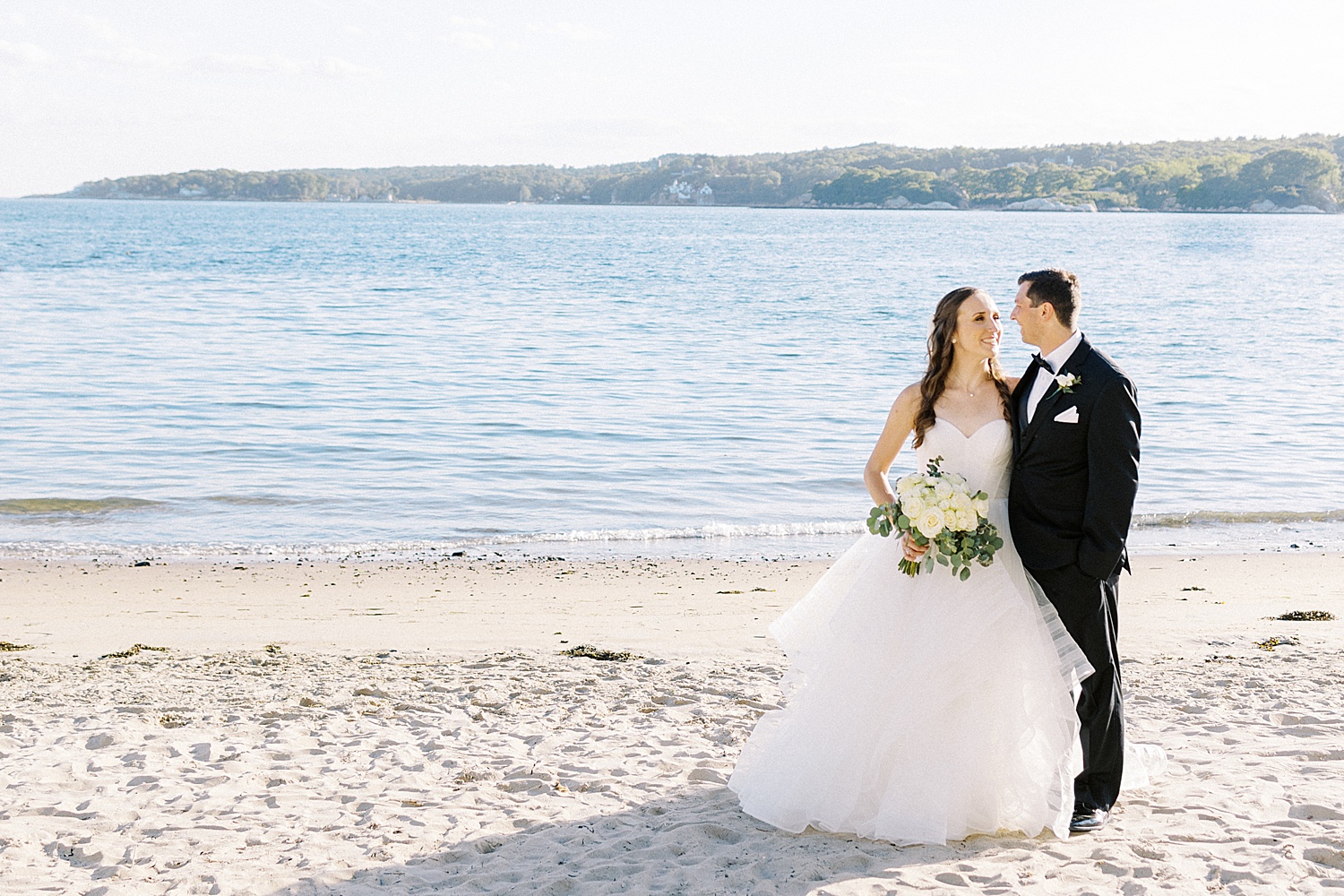 Newlyweds embracing on the beach by Lynne Reznick photography
