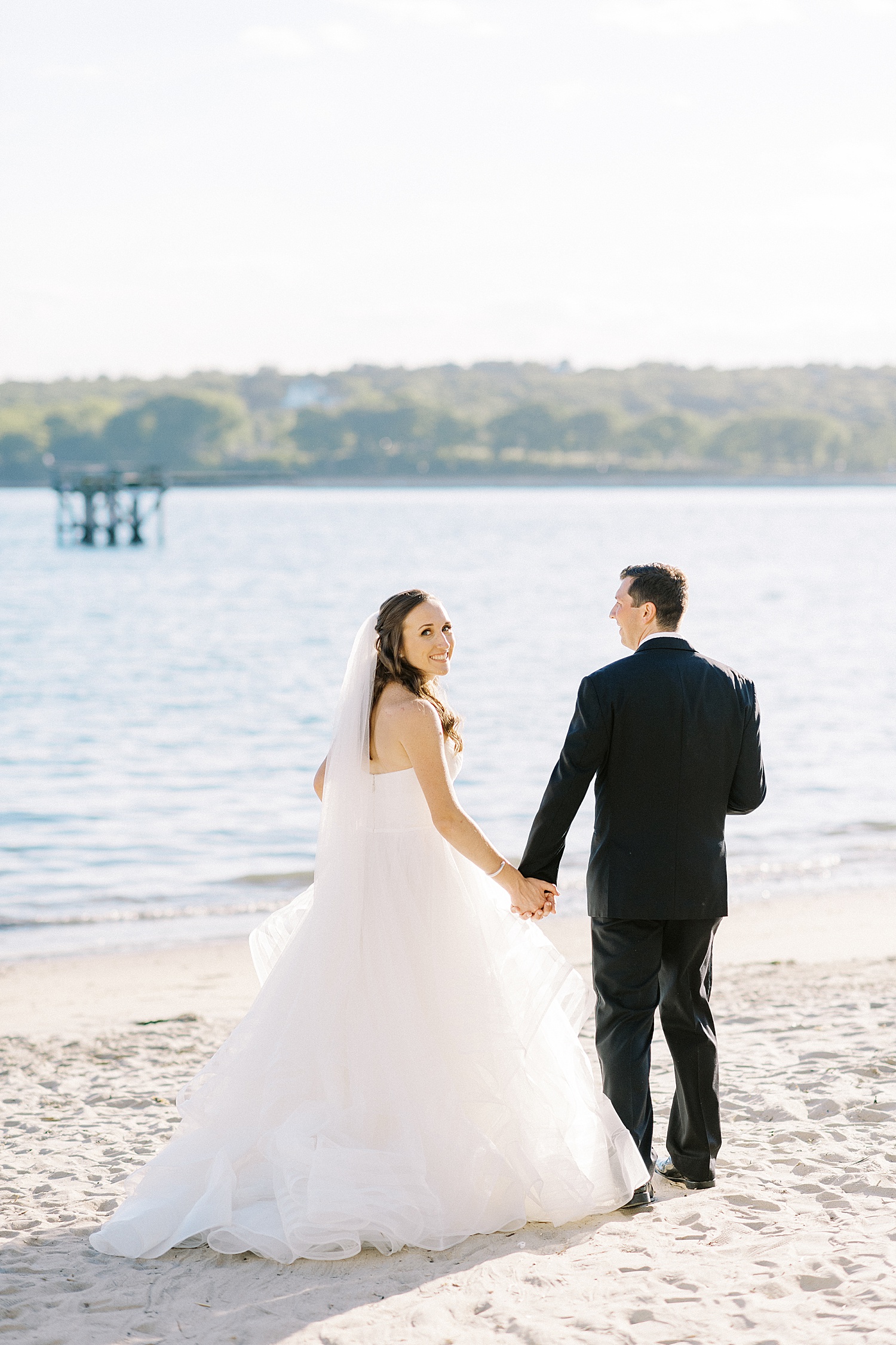 Newlyweds walking by the water by Lynne Reznick photography