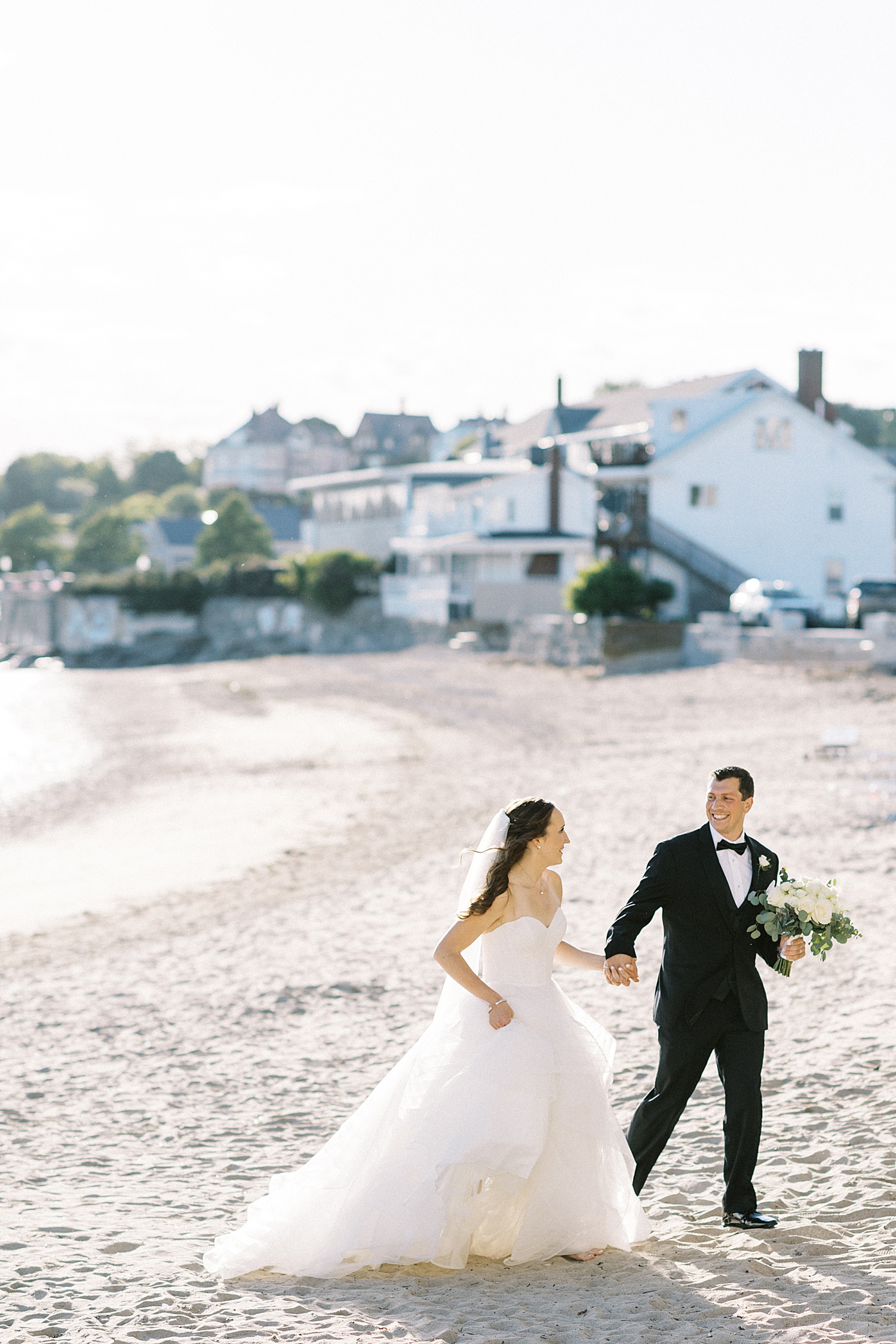 Newlyweds walking on the beach at Beauport Hotel