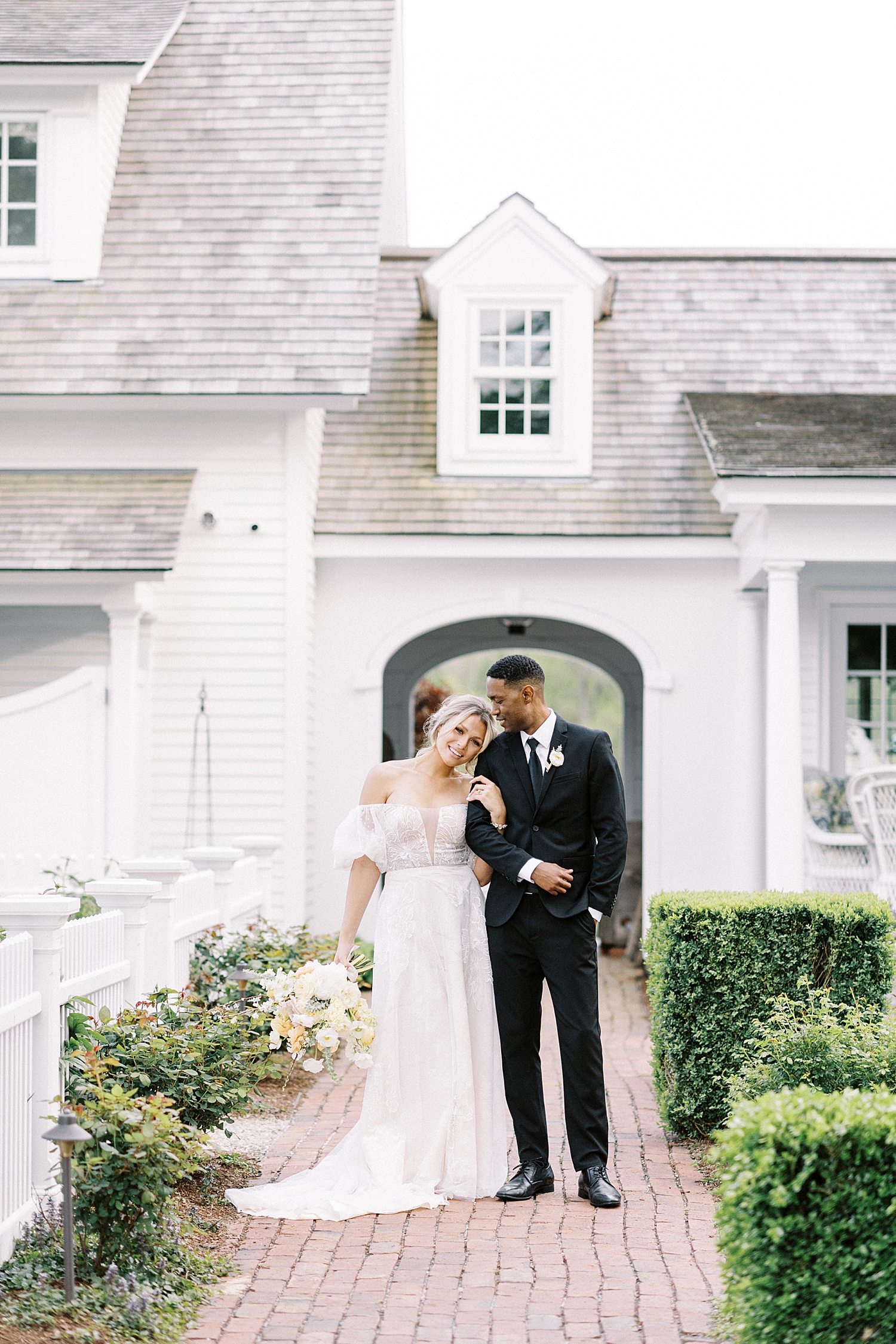 Bride and groom near cottage by Lynne Reznick Photography