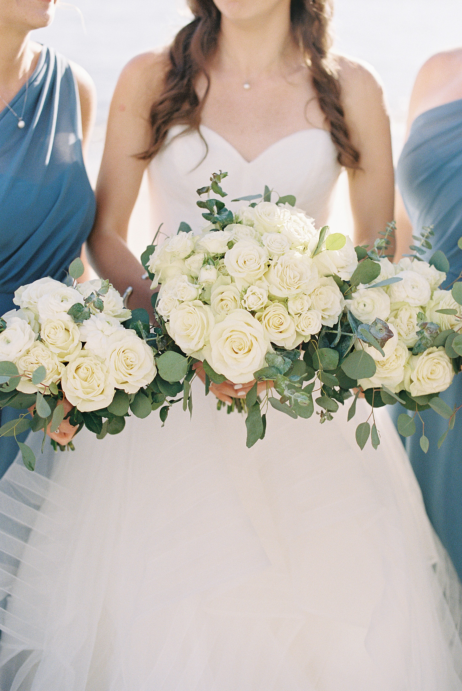 bride holding bouquet of white roses by Massachusetts wedding photographer