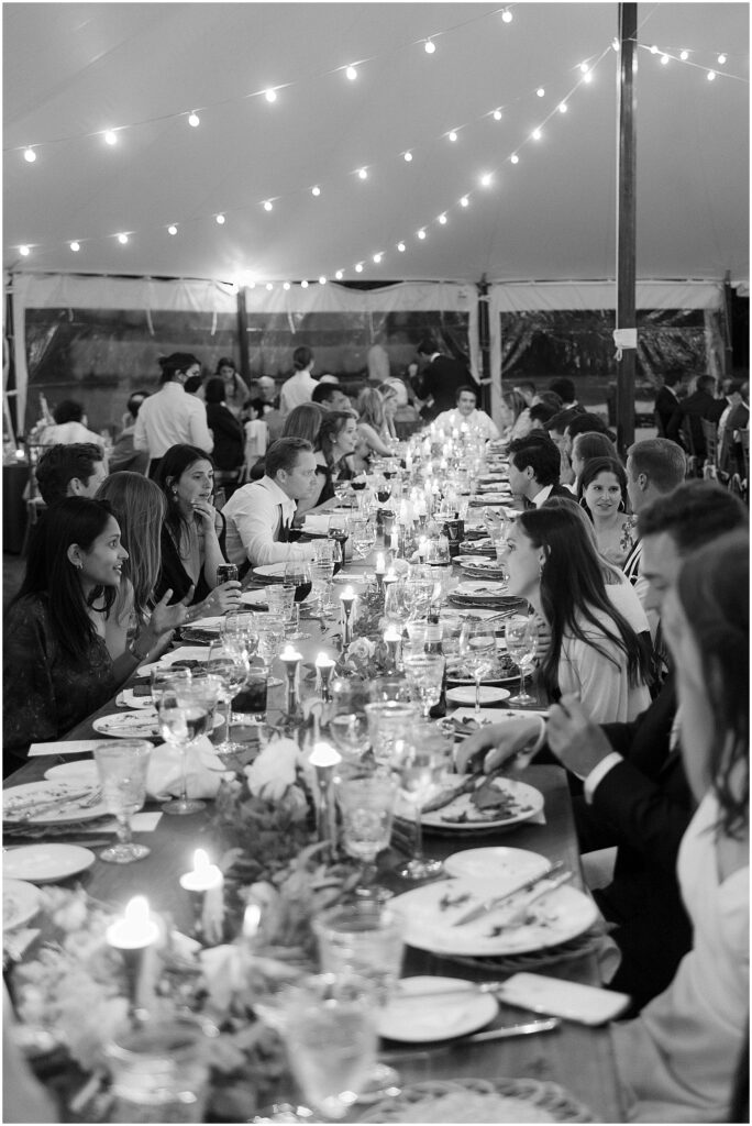 black and white of guests enjoying dinner at tented wedding reception in NY