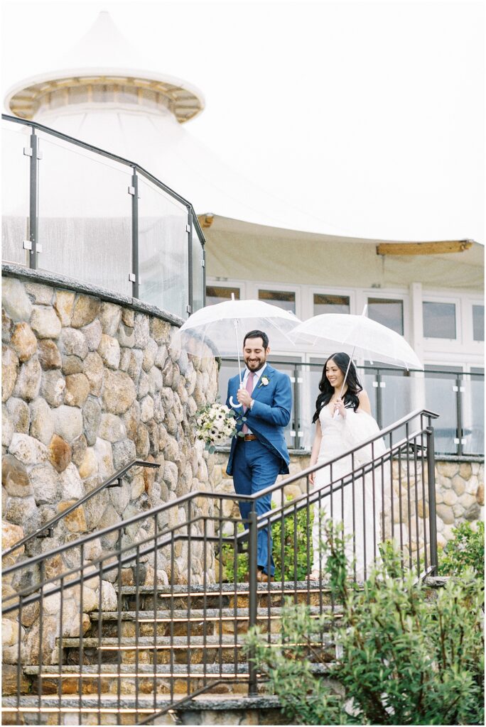 couple under clear umbrellas during spring wedding at wequassett resort