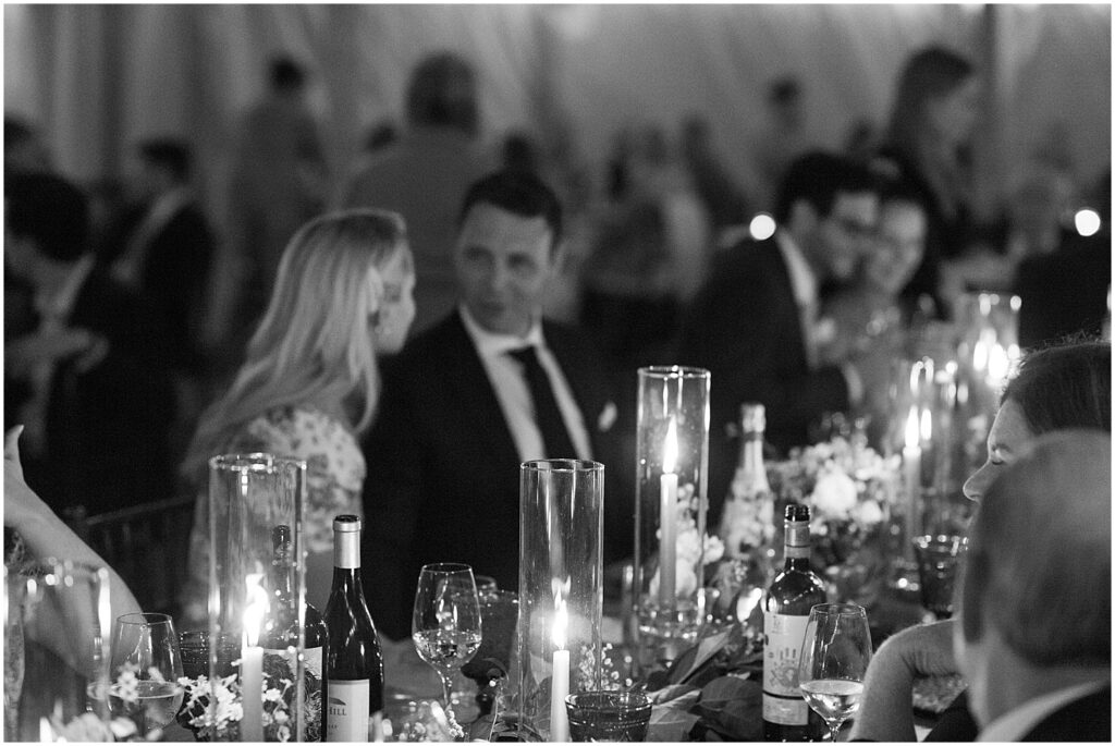 black and white of guests enjoying dinner by candlelight at cape cod wedding in Chatham