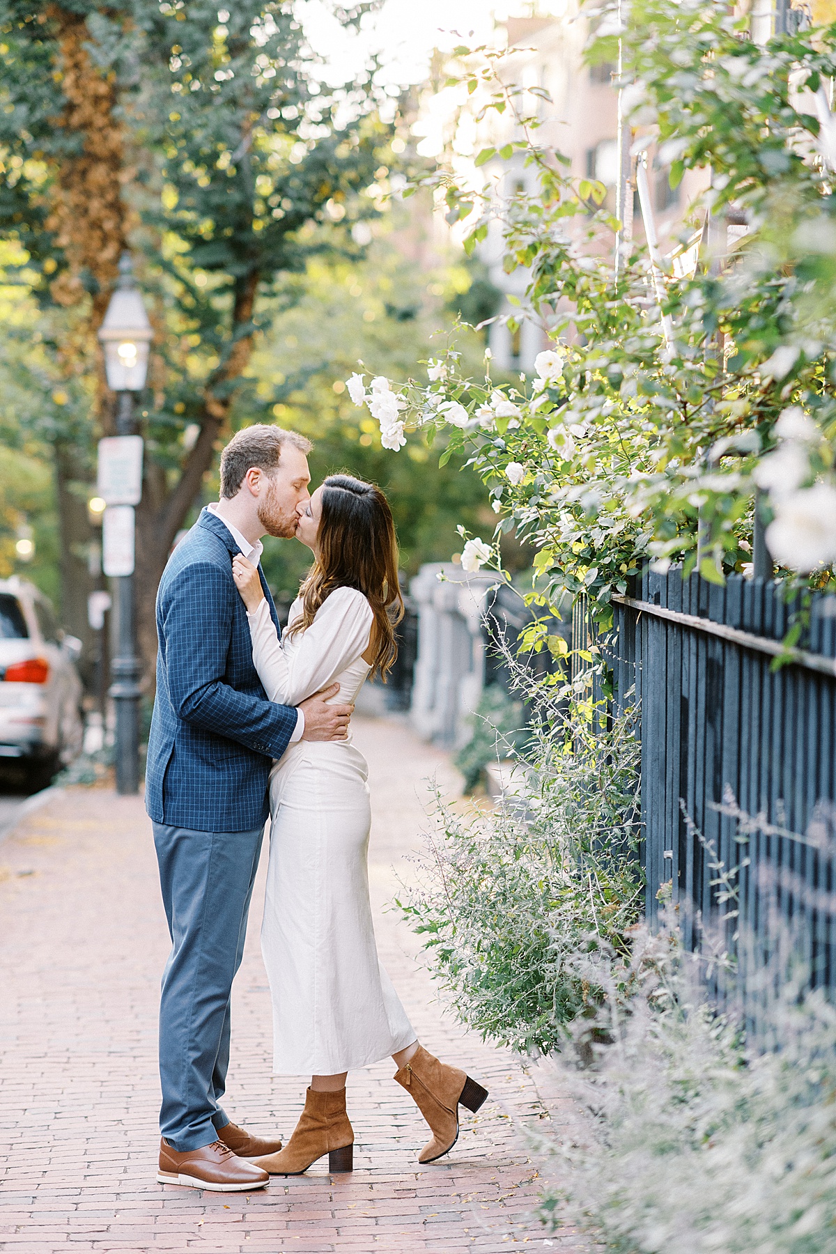 man and women kissing on the street of Public Garden for their engagement photos 