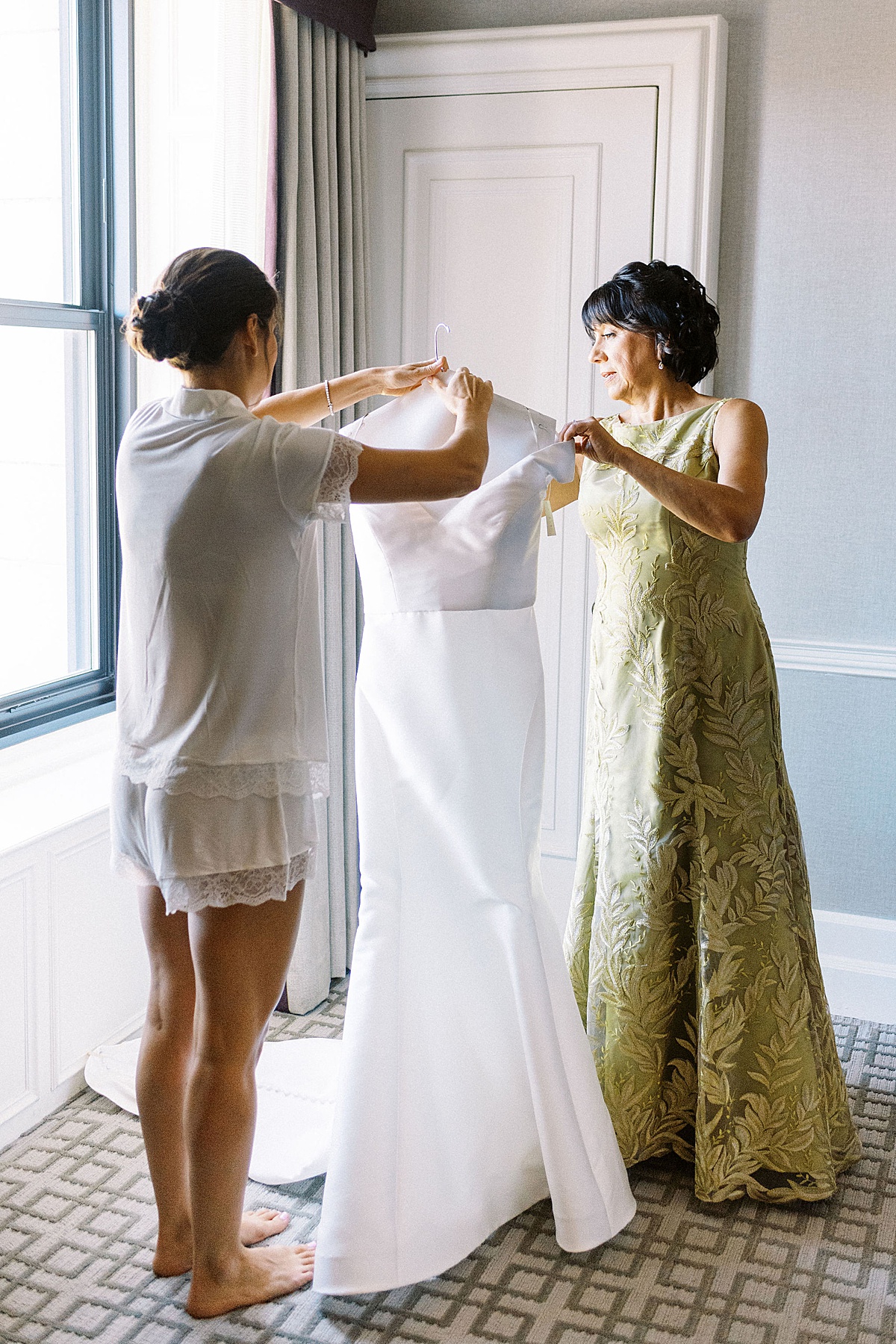 bride and mom taking dress out of bag in their Fairmont Copley Suite 