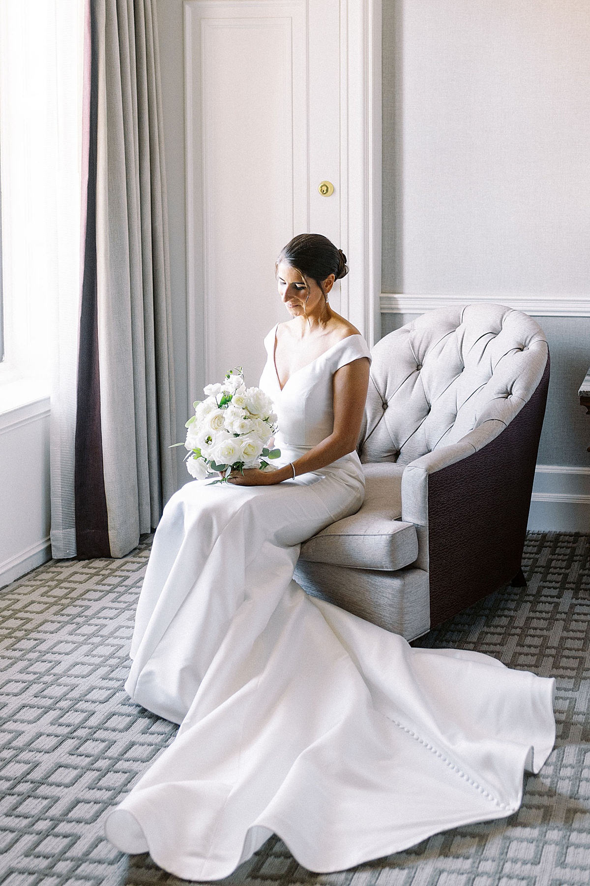 bride sitting in chair next to a window at the Fairmont Copley 
