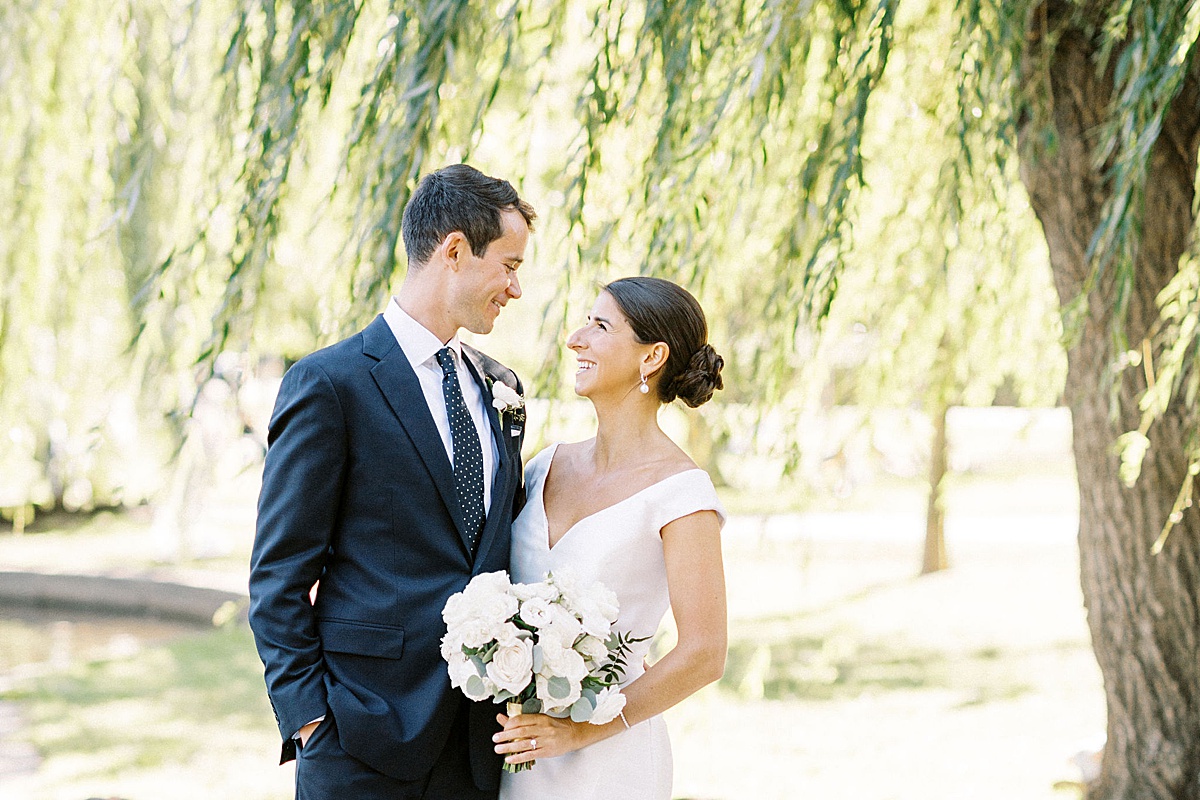 bride and groom smiling at each other  in Boston Public Garden captured by Lynne Reznick Photography 