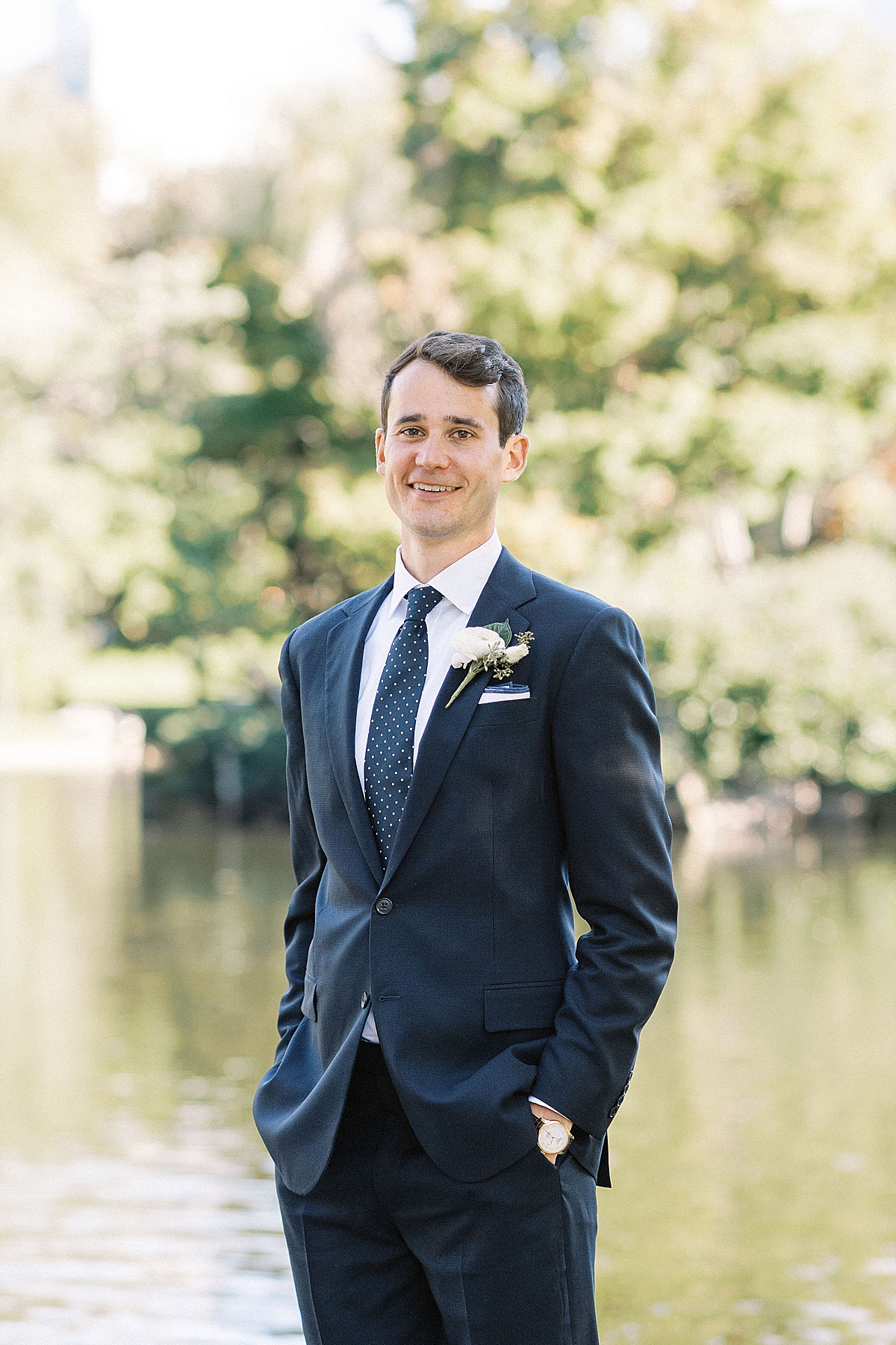 groom smiling at the camera while standing by water captured by Lynne Reznick Photography 