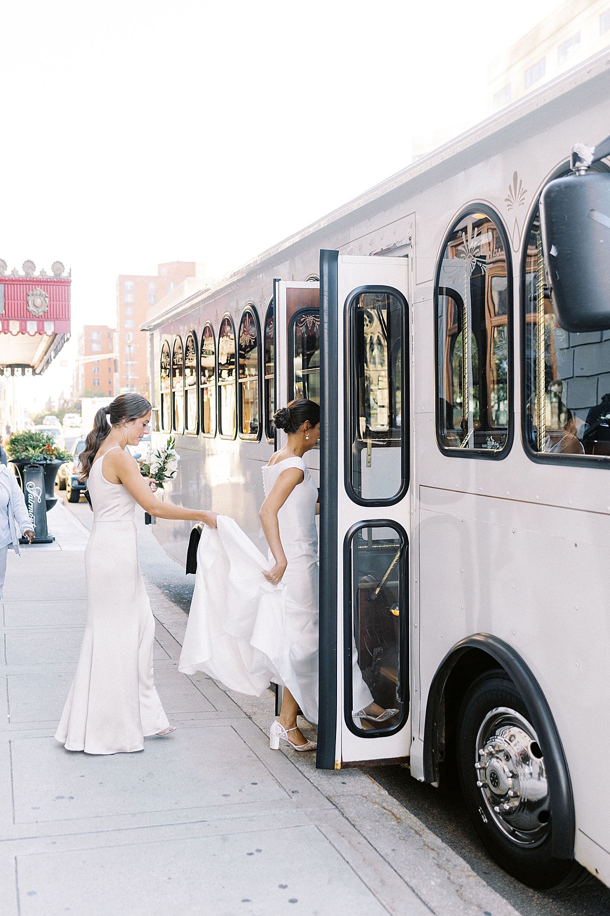 bridesmaid helping bride on to the trolly captured by Boston Wedding Photographer