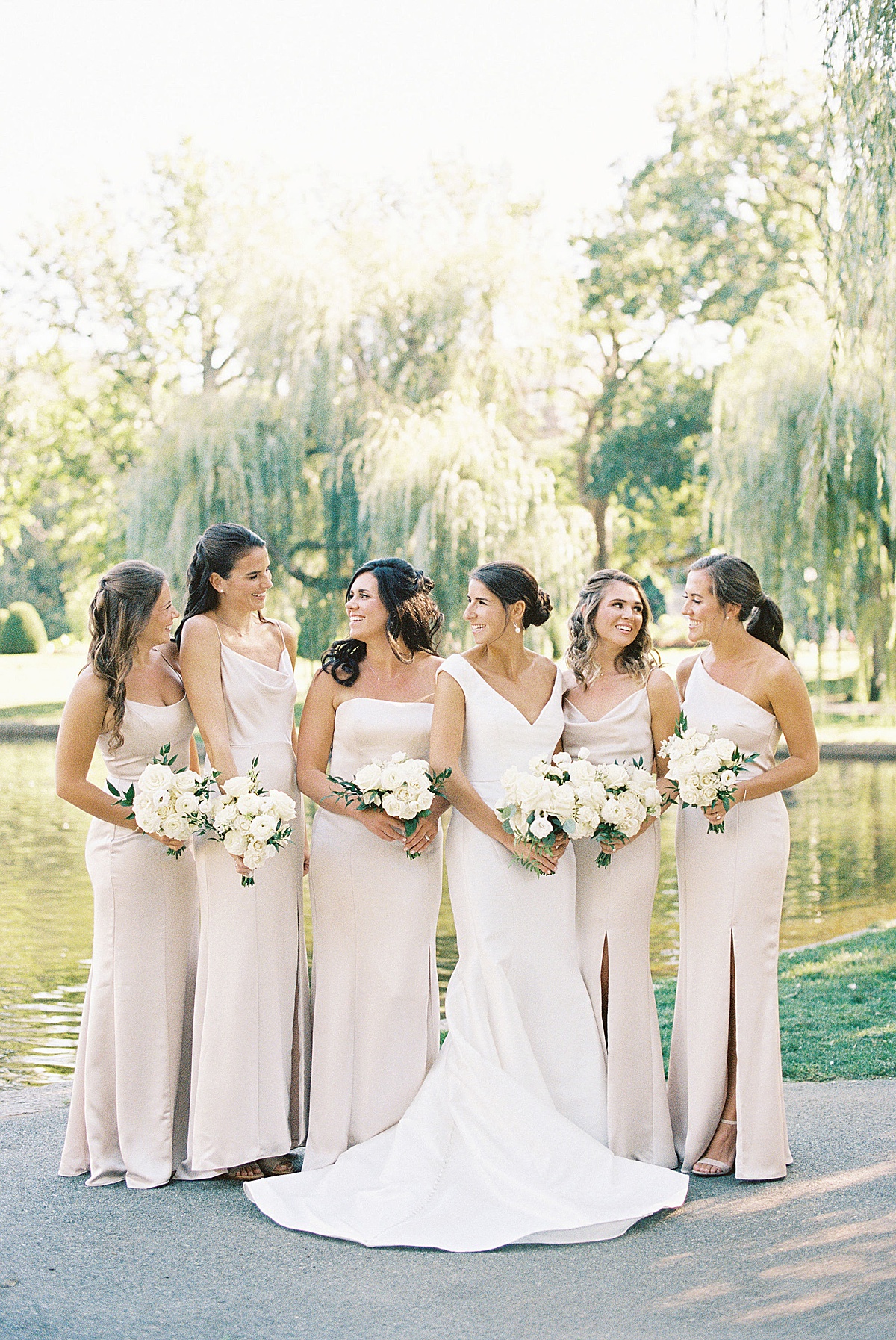 women laughing together during wedding party portraits at the Public Garden captured by Boston Wedding Photographer 