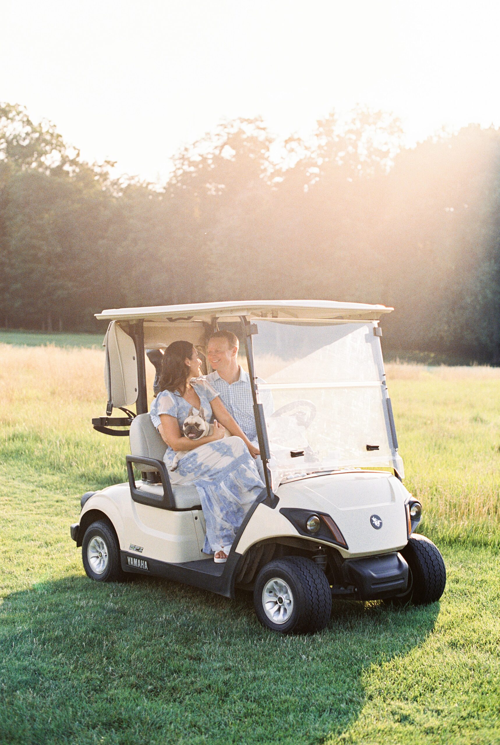 sunny golf couple in golf cart for engagement session with dog