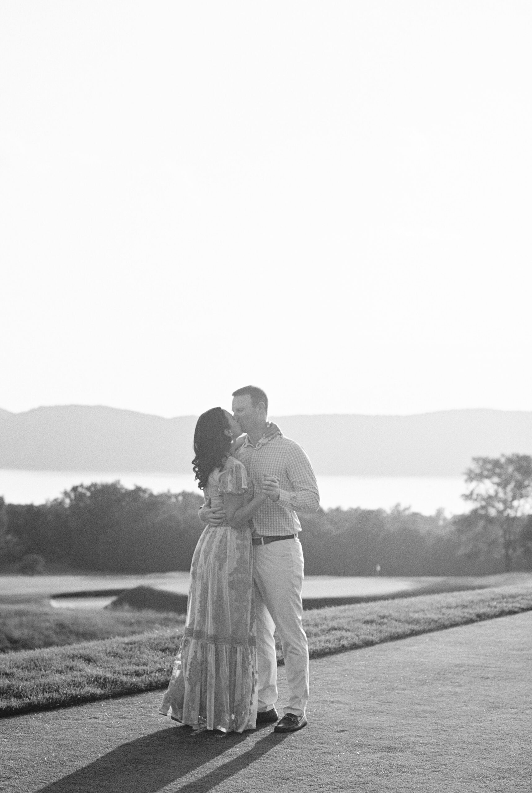 black and white of couple during country club engagement session on golf course overlooking Hudson River