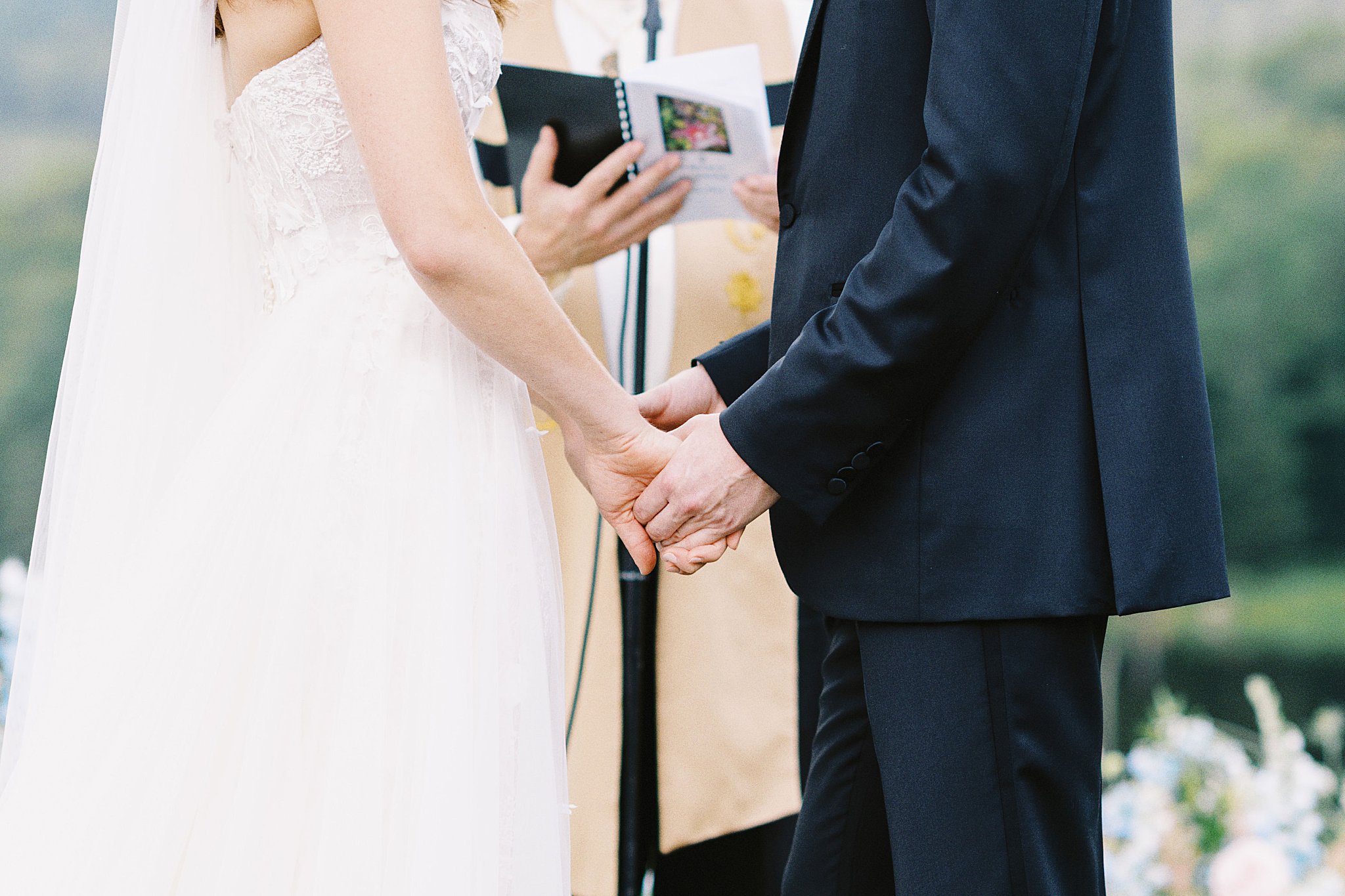 couple holds hands at the altar at Onteora Club