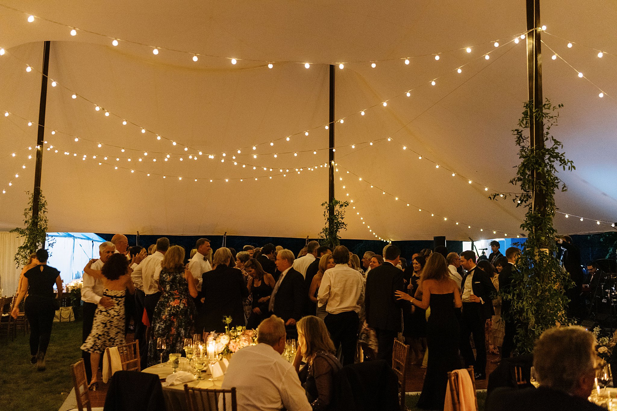 tented reception lit by string lights by Catskills wedding photographer
