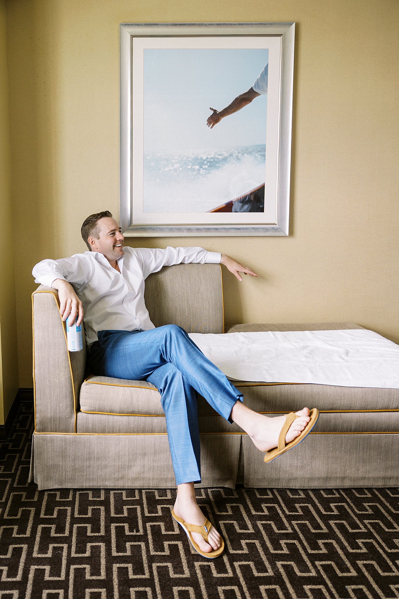 groom relaxes on couch before ceremony by Cape Cod wedding photographer