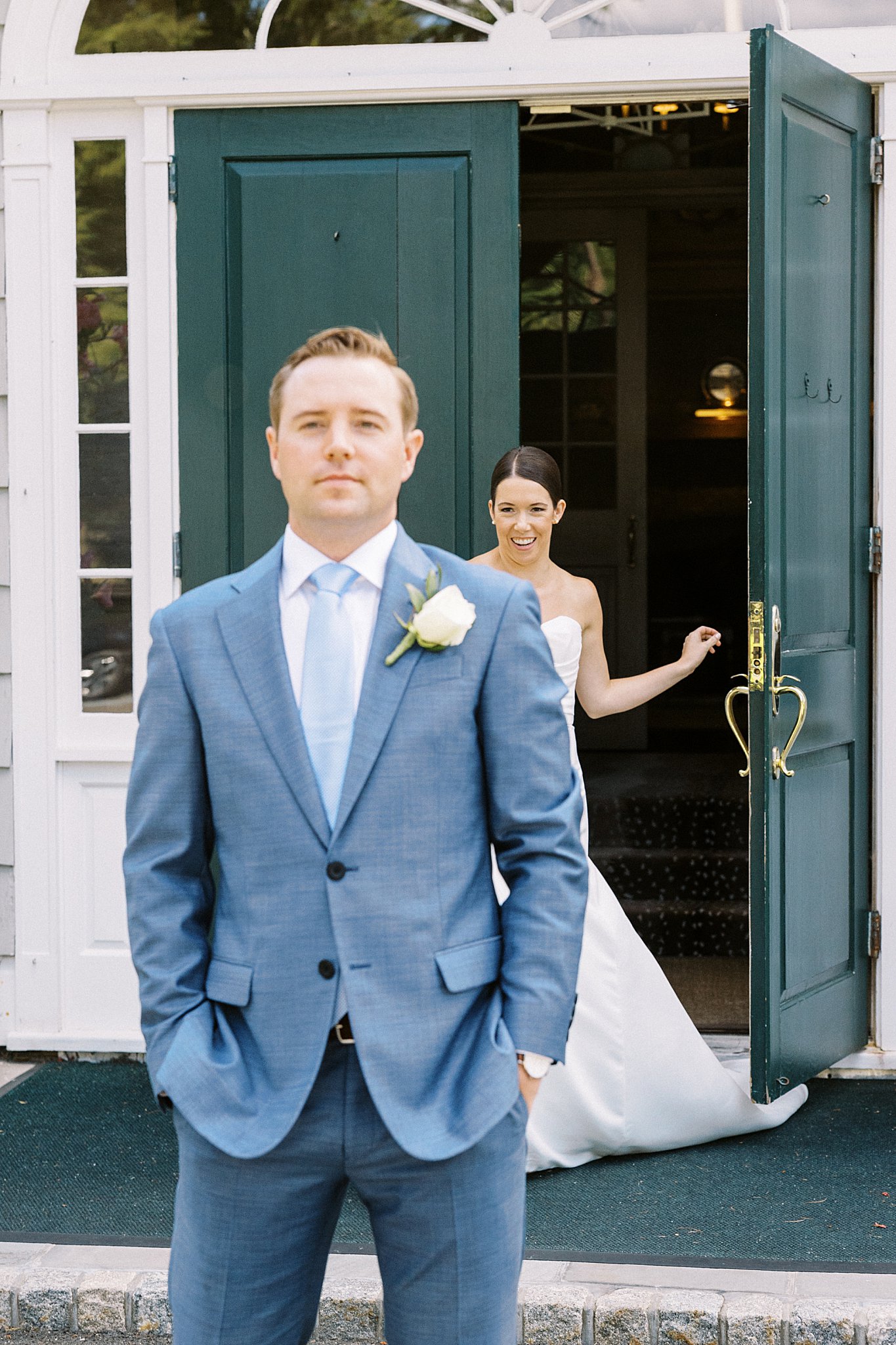 bride walks out door behind groom for first look by Lynne Reznick Photography 