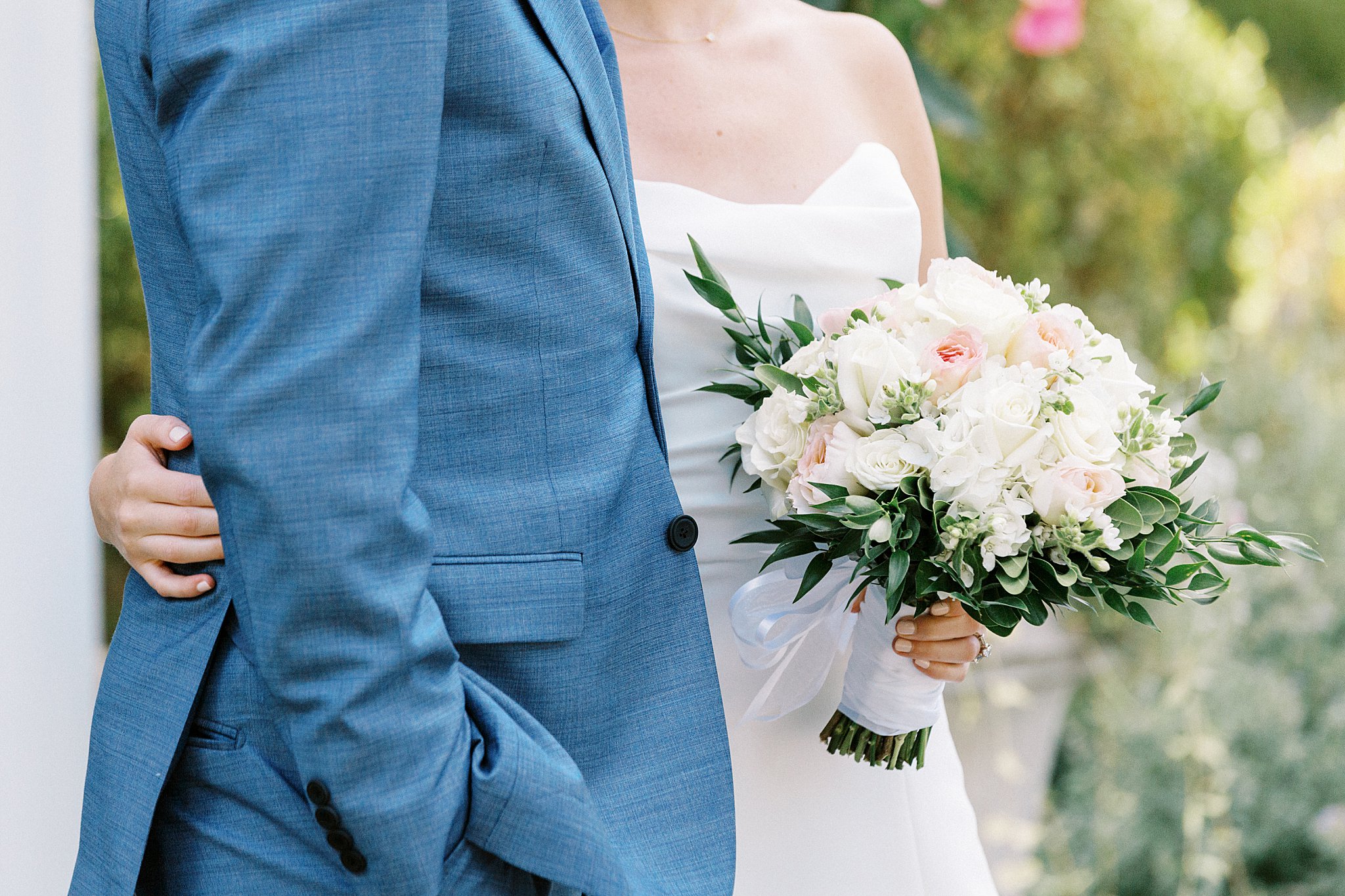 woman holds bridal florals and puts hand around man by Lynne Reznick Photography 