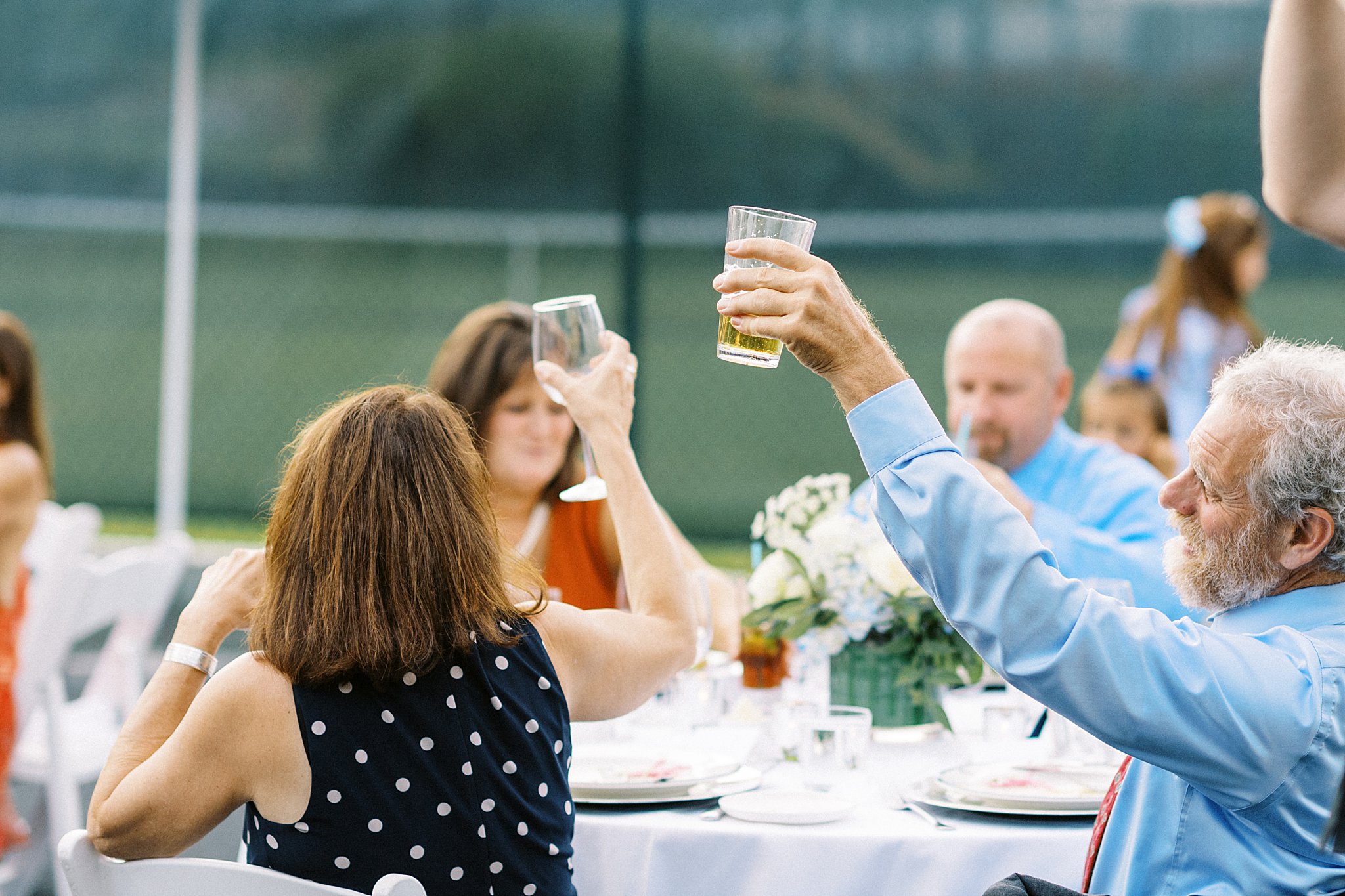 guests raise glasses during a toast by Lynne Reznick Photography 