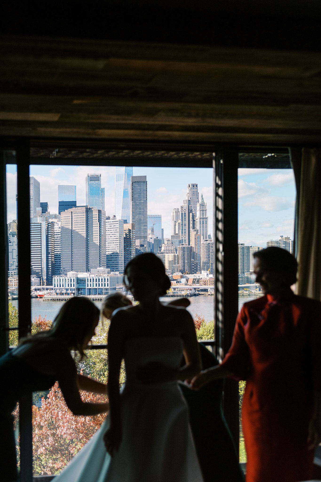 skyline peeks through window as bride gets ready before heading to Brooklyn Heights Casino