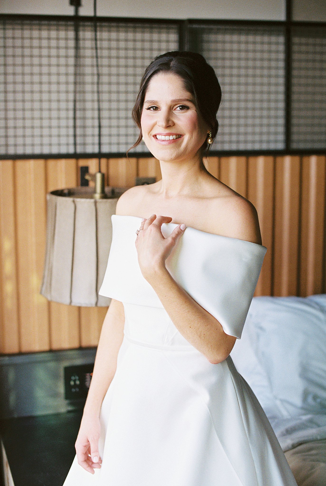 bride smiles and touches dress by Lynne Reznick Photography