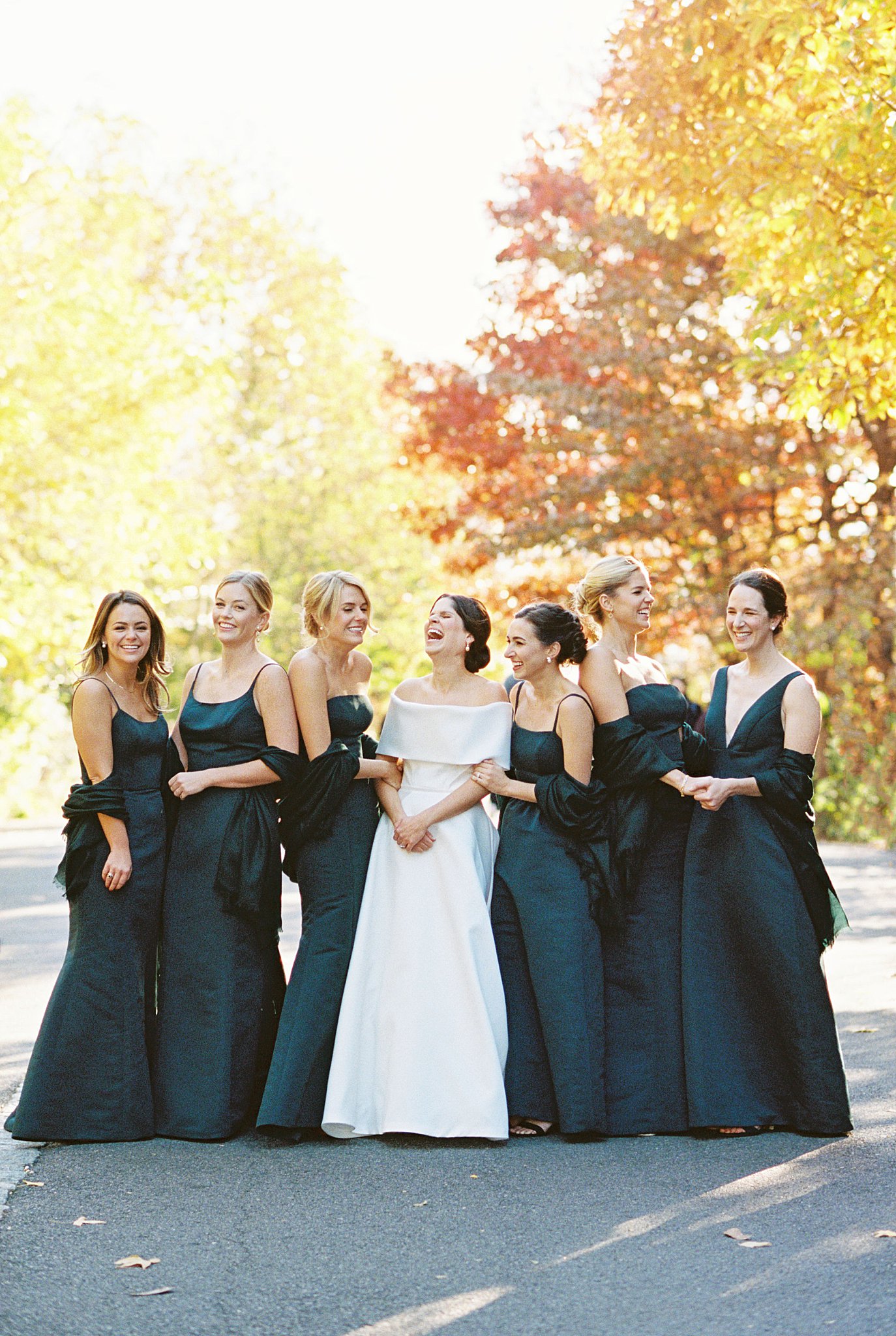 bridesmaids laugh together with fall colors behind by NYC wedding photographer 