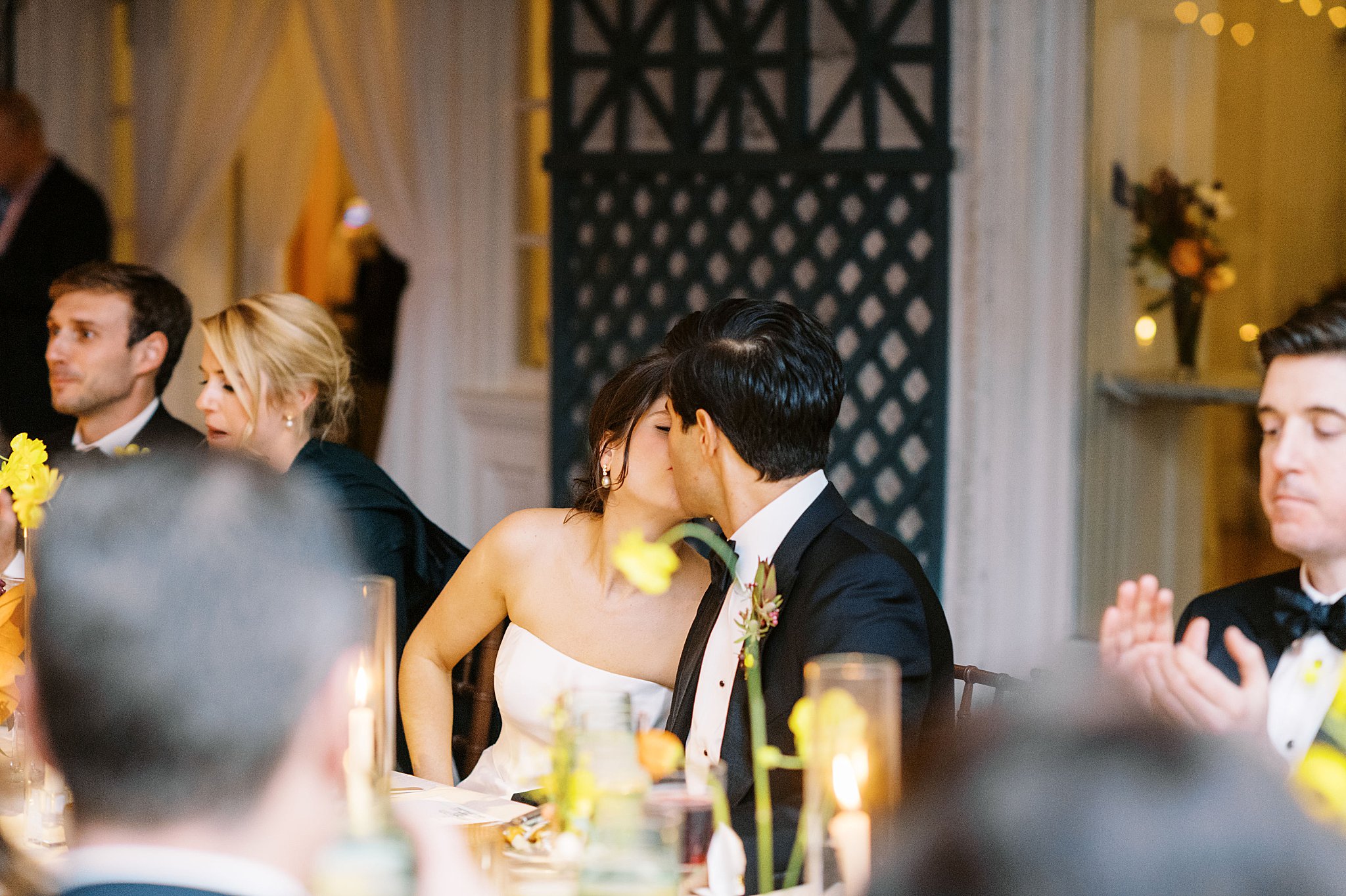 couple kisses at reception by NYC wedding photographer 