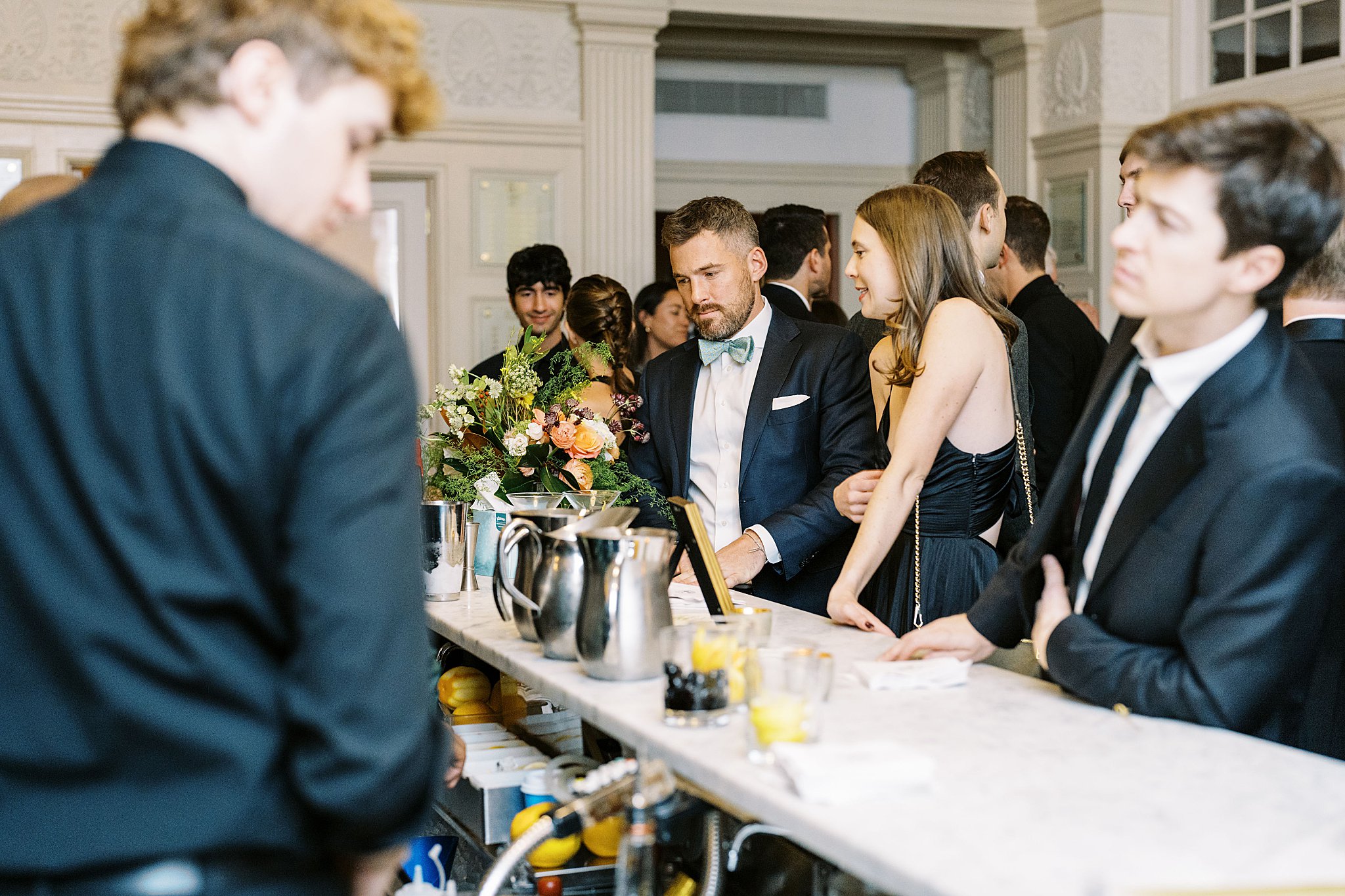 guests get drinks at bar by NYC wedding photographer 