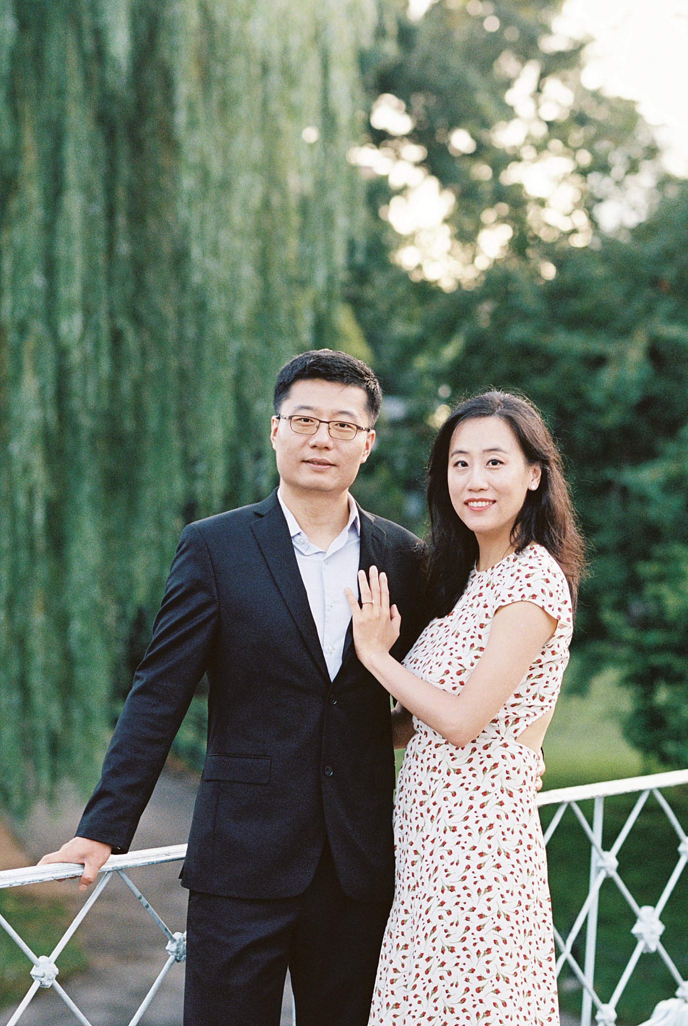 woman rests her hand on man's chest as he leans on gate during Public Garden Anniversary session