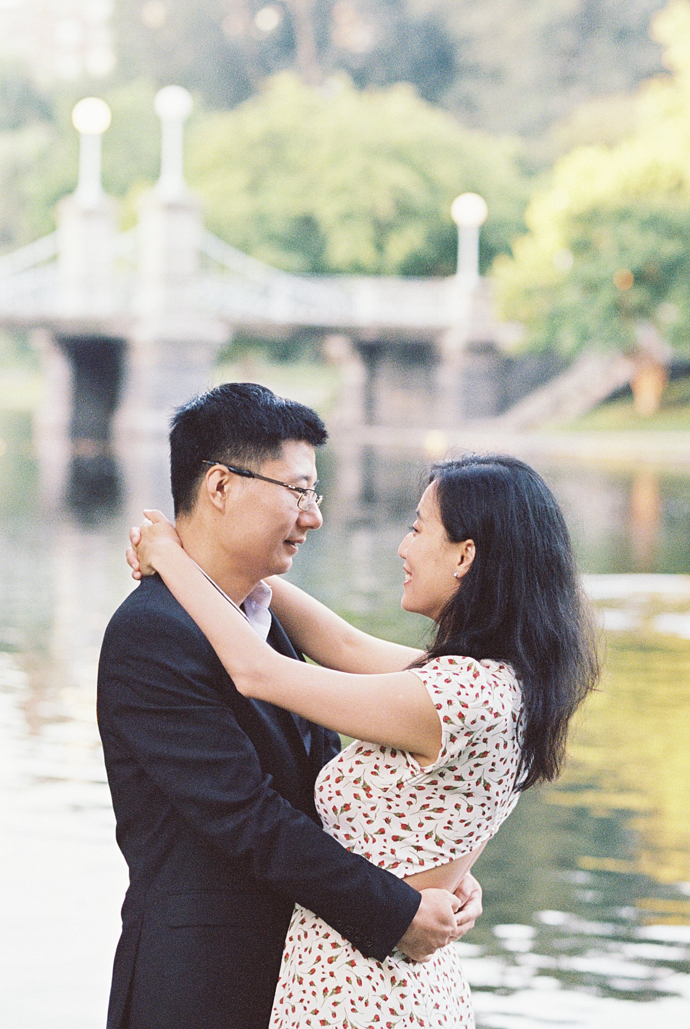 wife wraps arms around husband's neck as they smile at each other by Boston photographer