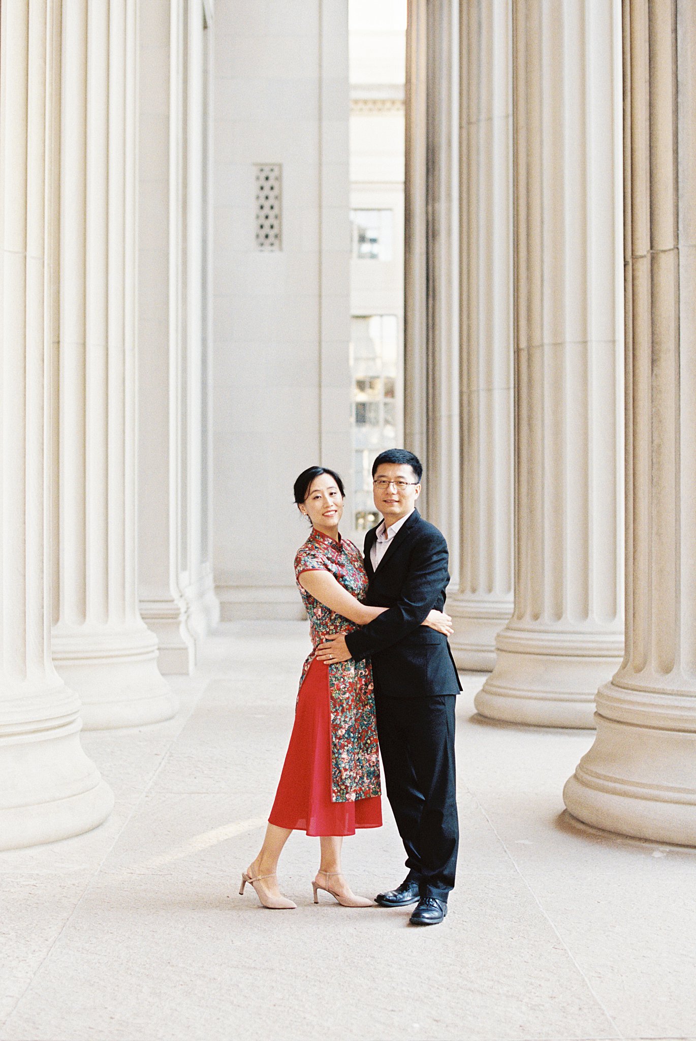 couple puts hands around each other's waists at MIT Dome Building portrait session