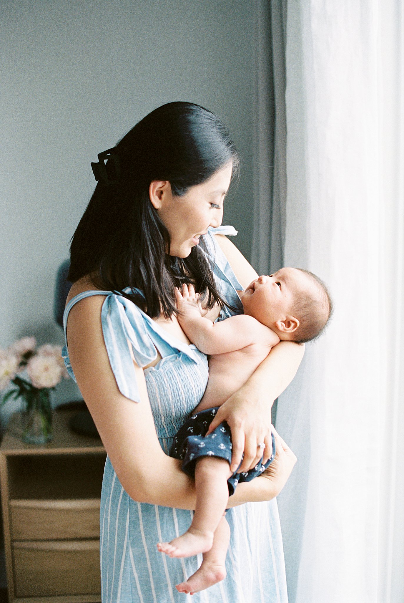 baby looks up at his mom by Lynne Reznick Photography