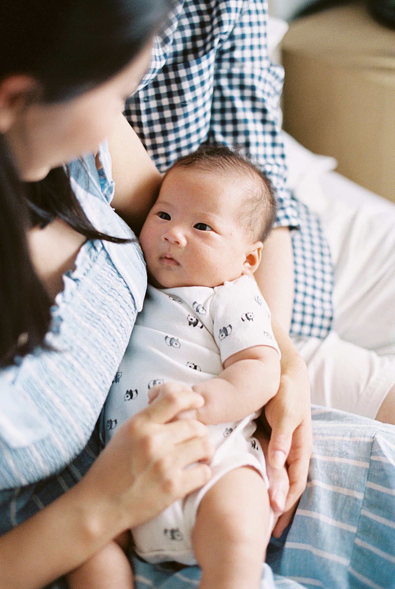 baby looks up at mother during in-home lifestyle session