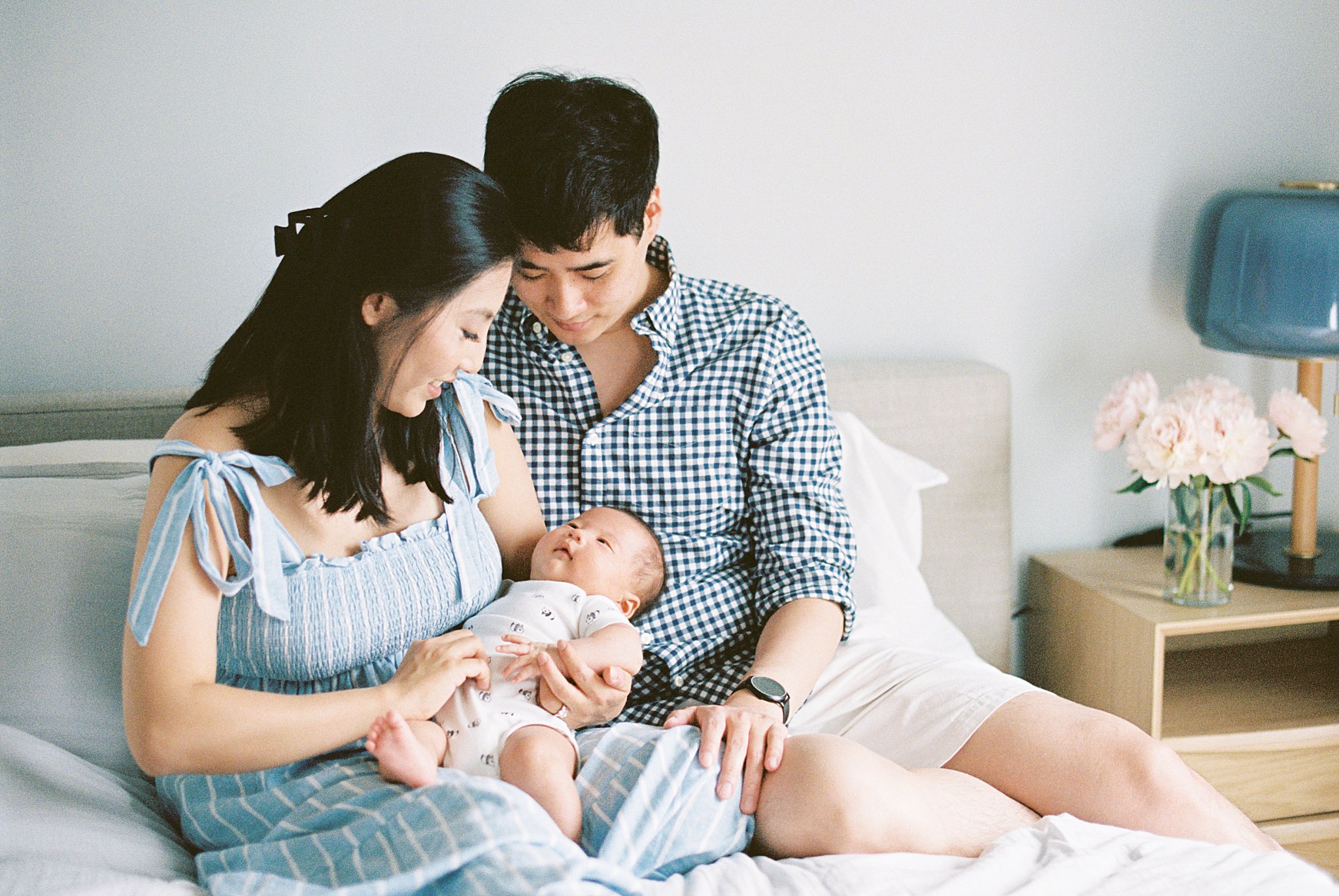 parents hold baby on their bed by Boston family portrait photographer