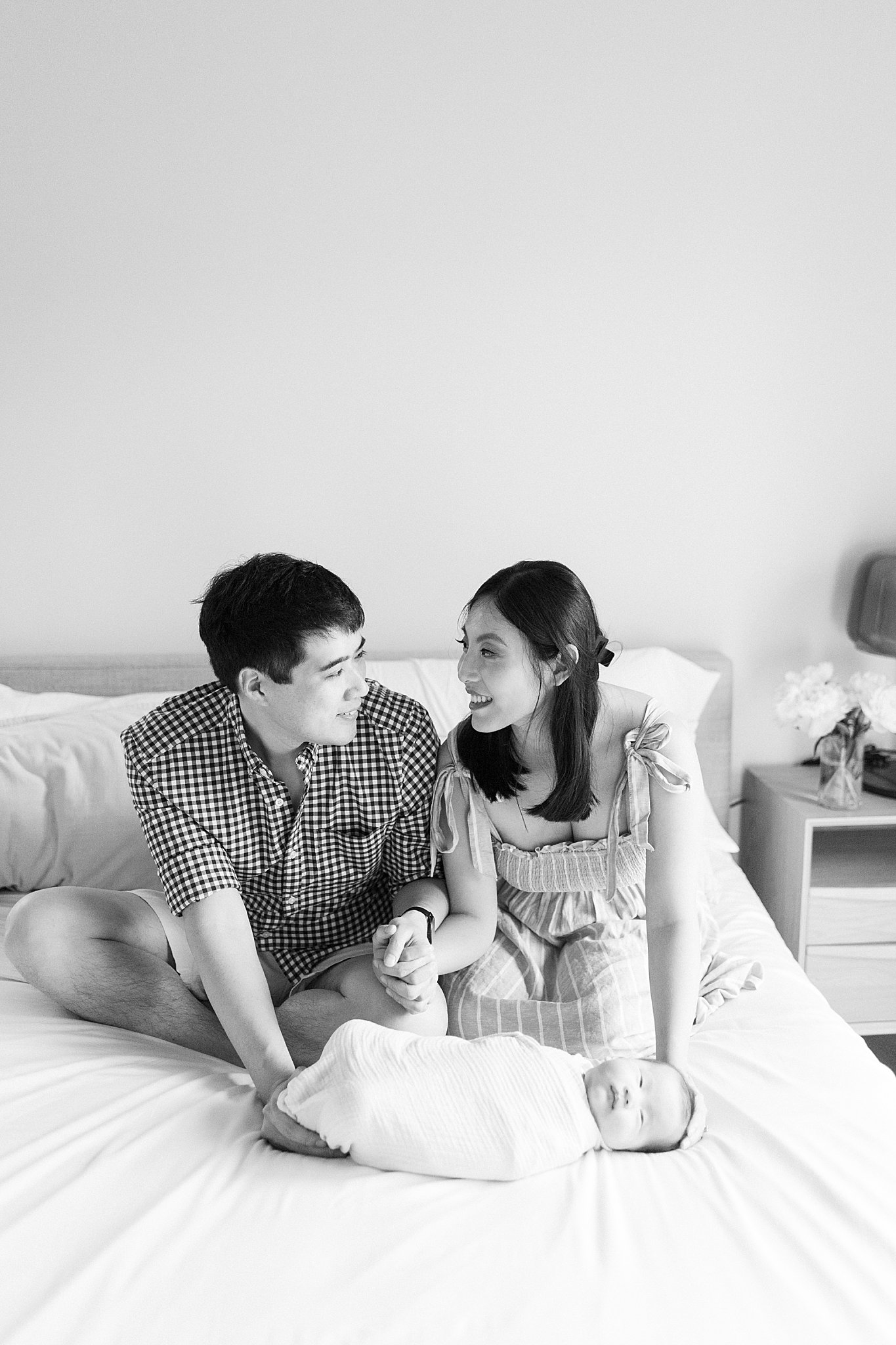 couple looks at each other as they hold their baby by Lynne Reznick Photography