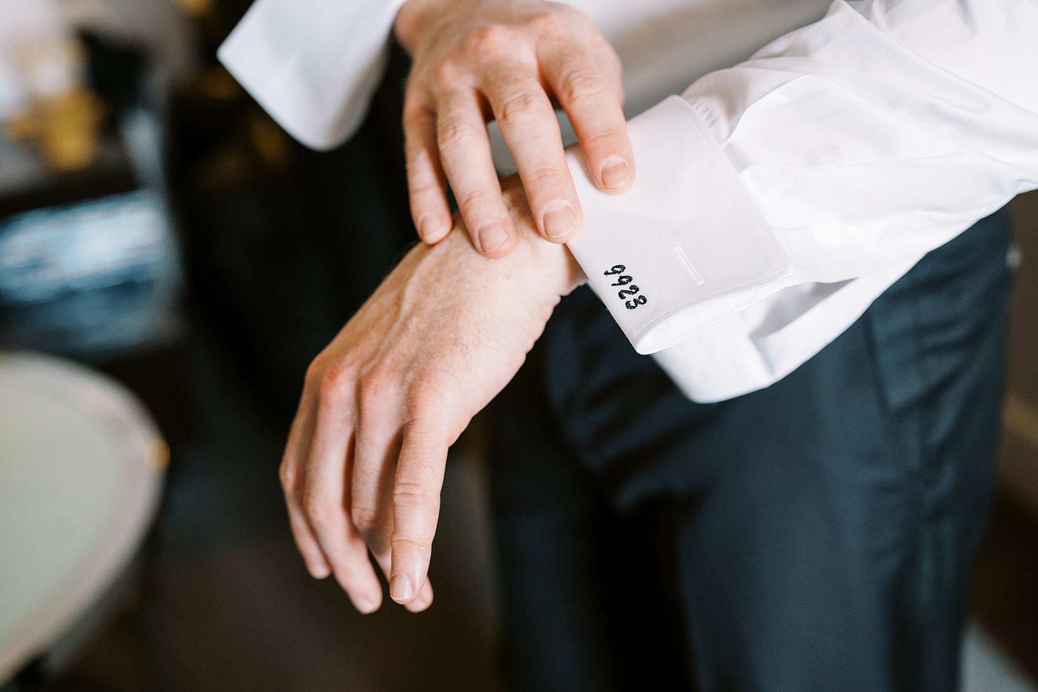 groom adjusts cuffs by Boston Wedding Photographer