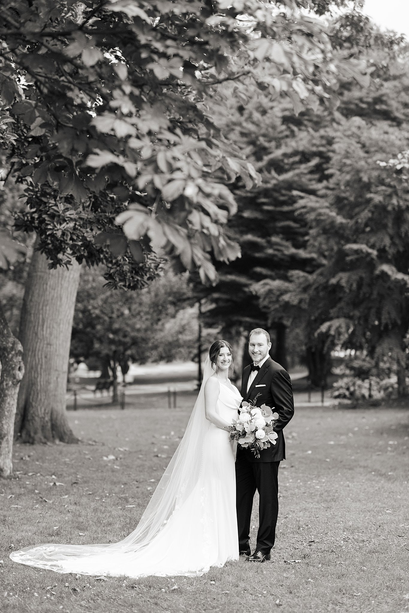 couple holds bridal bouquet and smiles by Boston Wedding Photographer