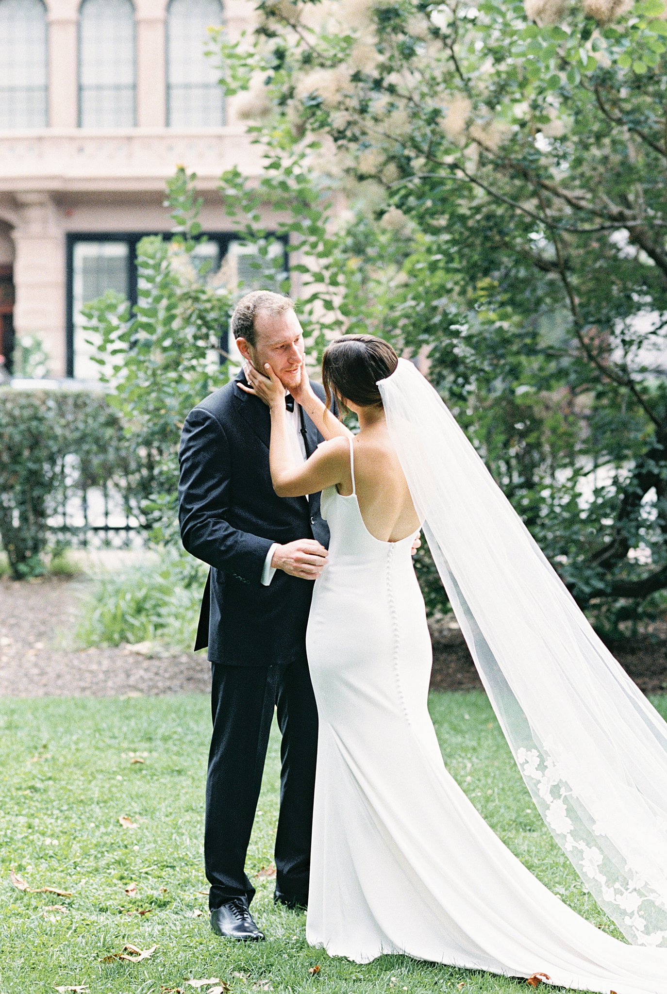 bride holds groom's face during first look before Museum of Science ceremony