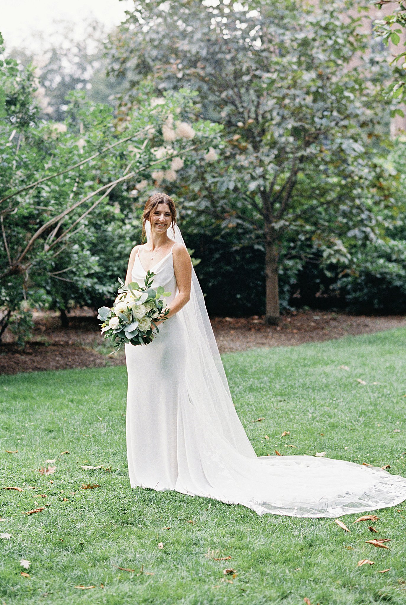 woman in bridal gown holds florals by Lynne Reznick Photography