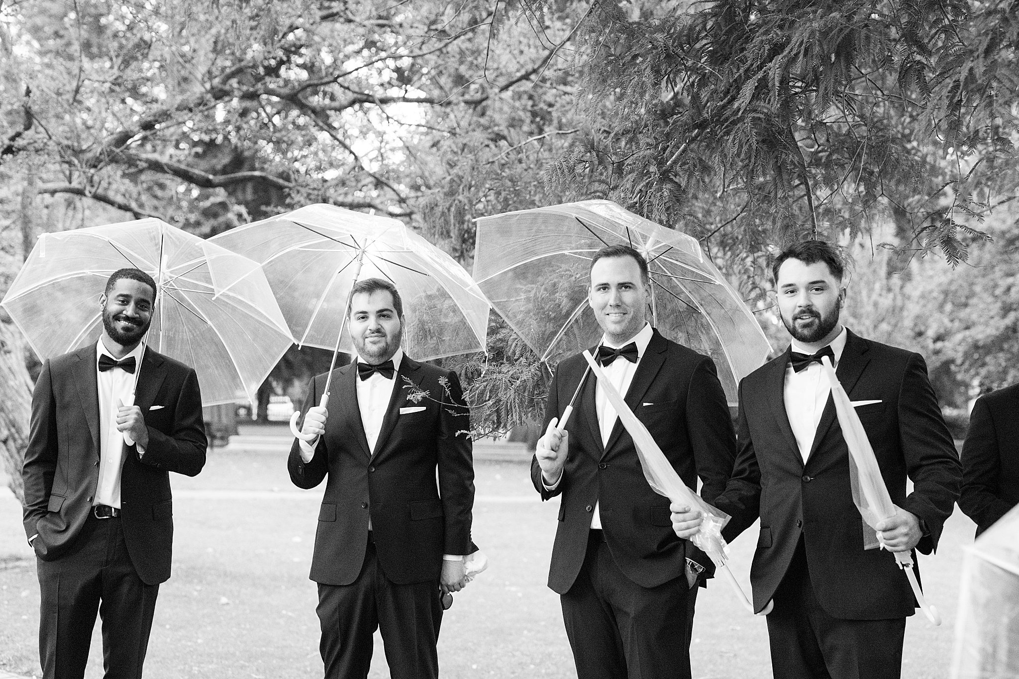 groomsmen hold umbrellas by Boston Wedding Photographer