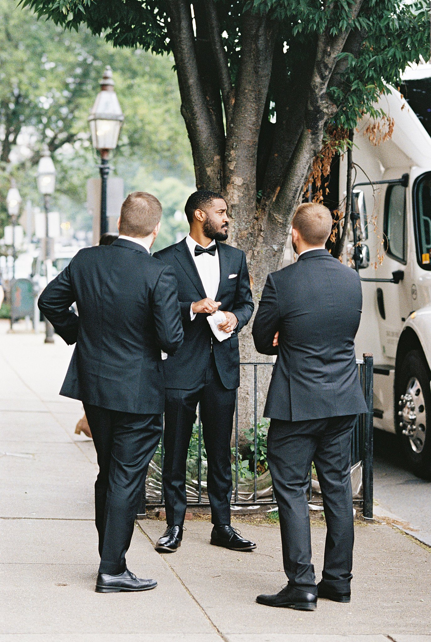 groomsmen wait outside bus by Lynne Reznick Photography