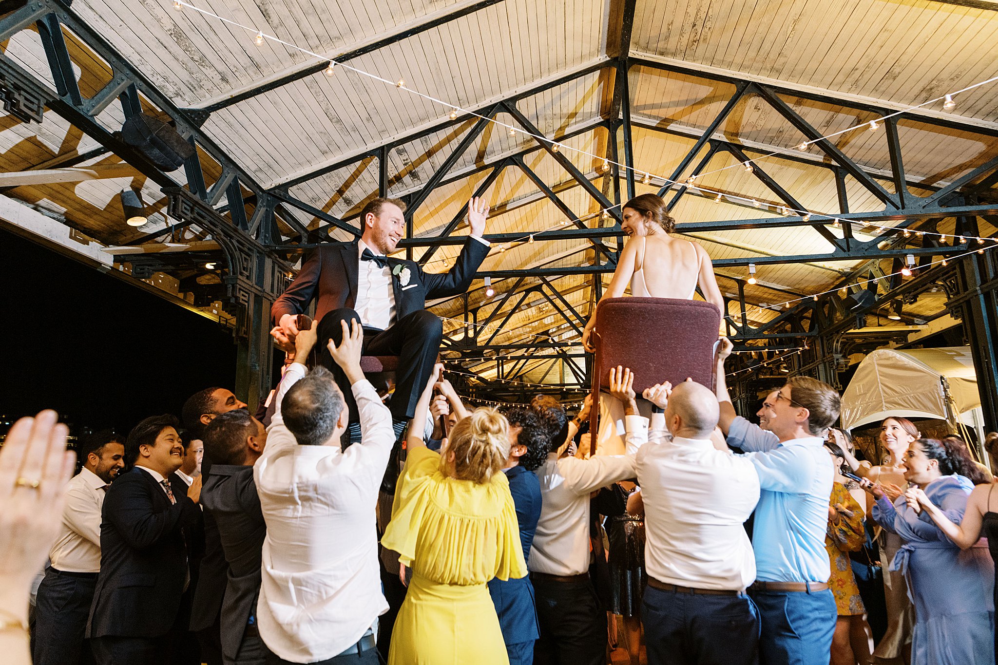 bride and groom lifted in chairs during reception at Museum of Science 