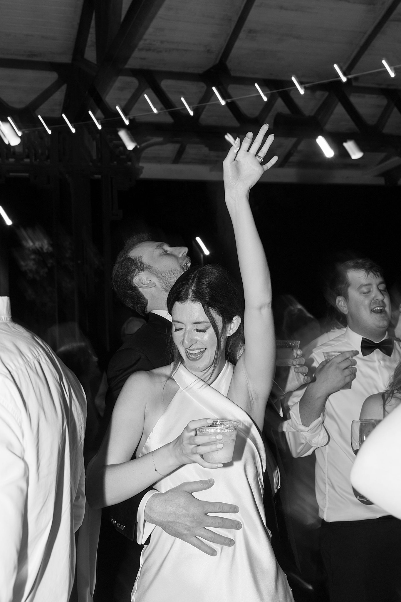 bride dances with drink in hand at Museum of Science 