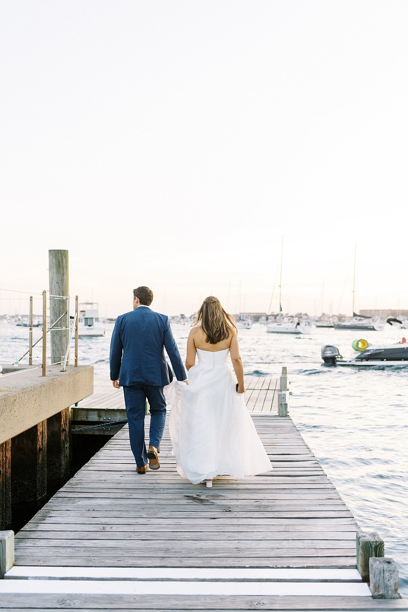 couple walks together on docks near The Bohlin