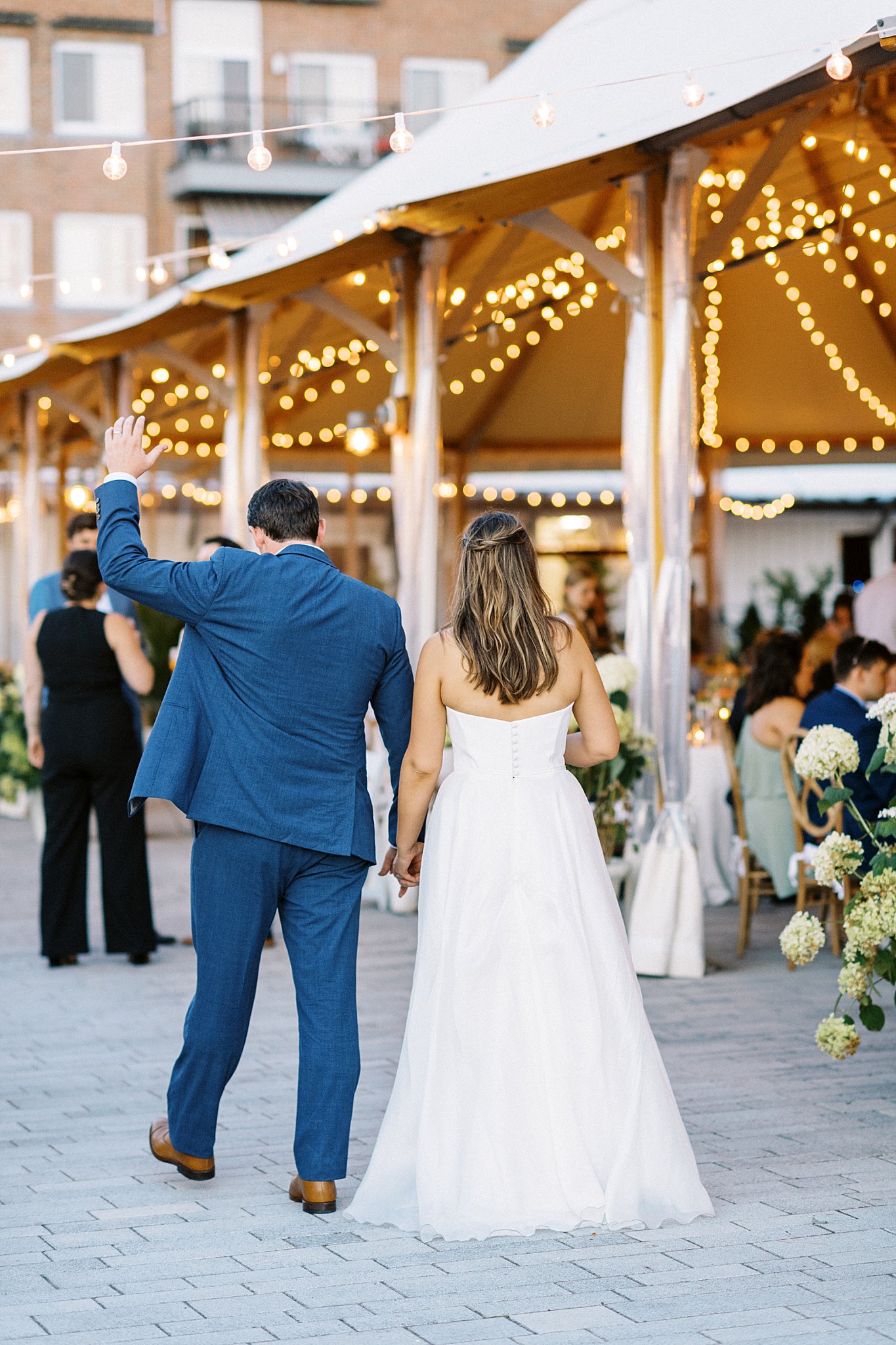 bride and groom enter the reception with groom waving by Lynne Reznick Photography