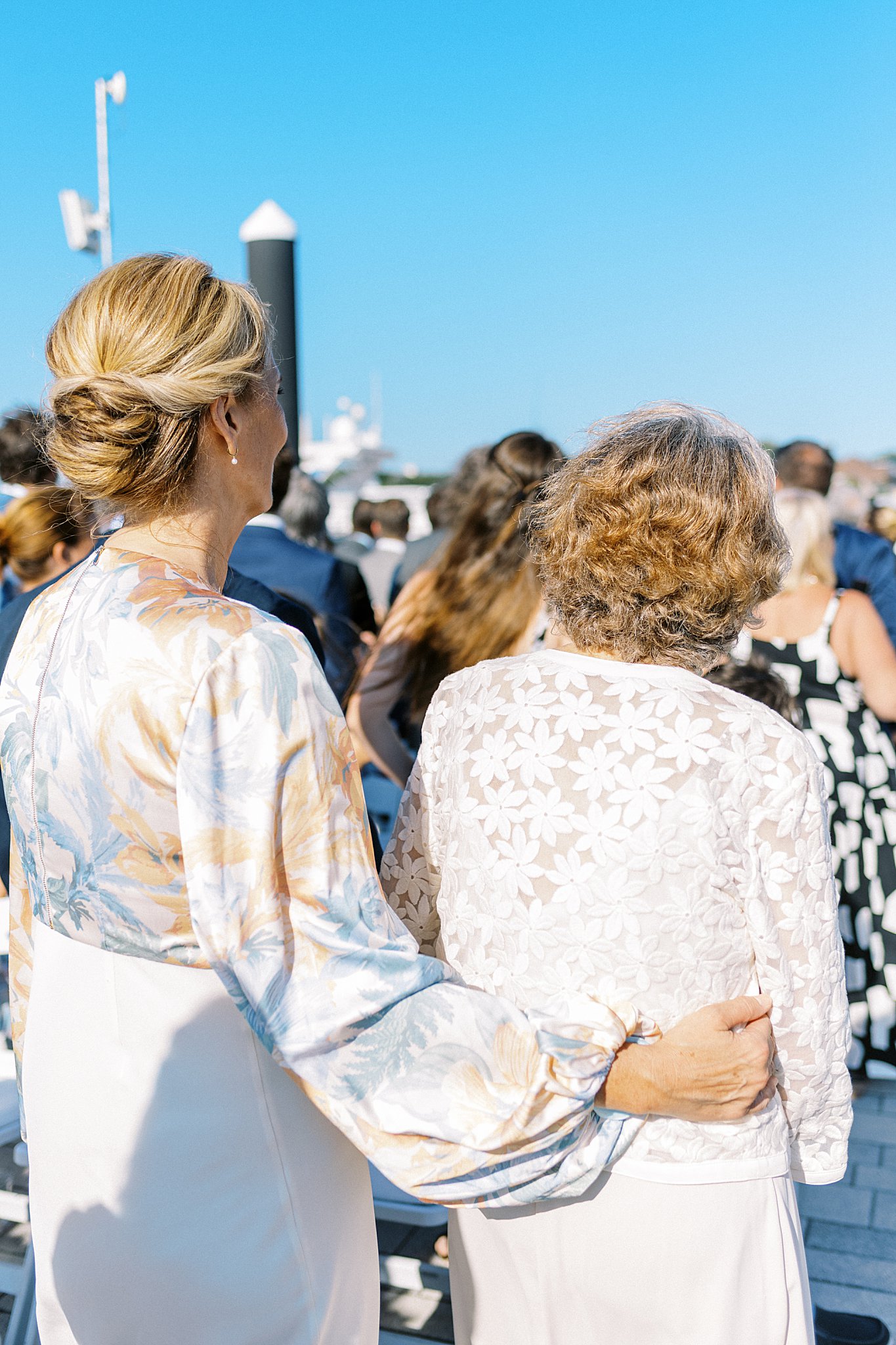 guests watch ceremony with arms around each other by Boston wedding photographer