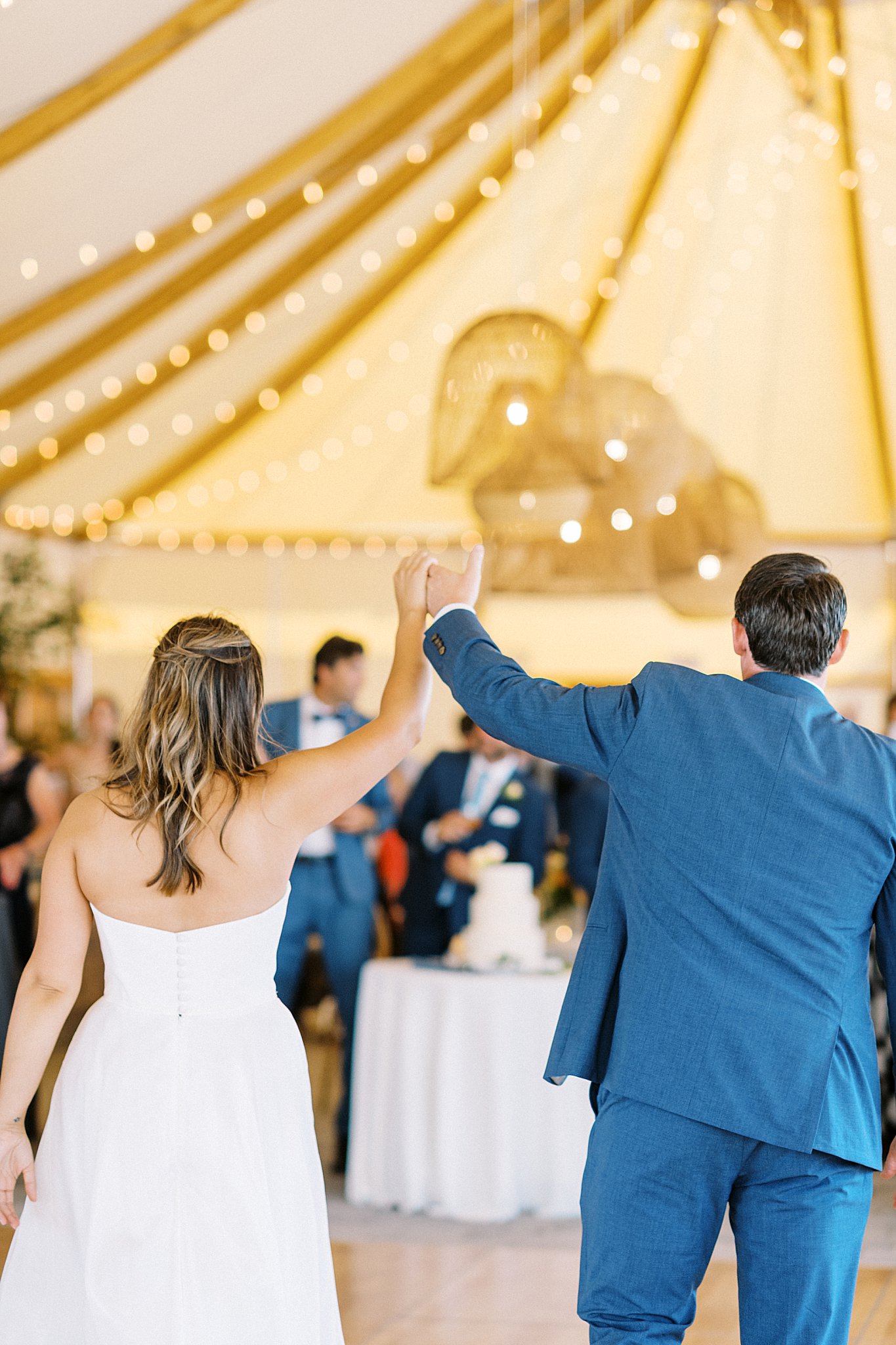 newlyweds enter the reception with hands in the air at The Bohlin